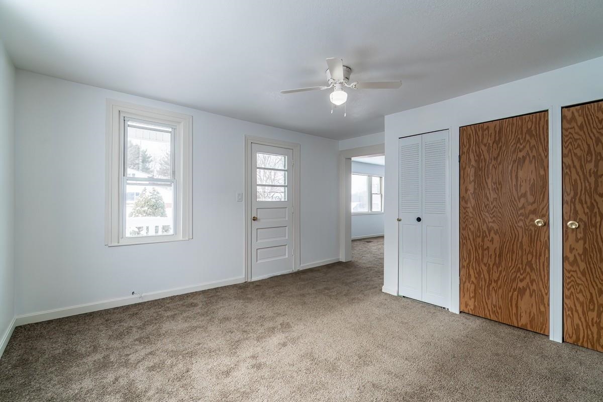 Carpeted entryway featuring baseboards and ceiling fan