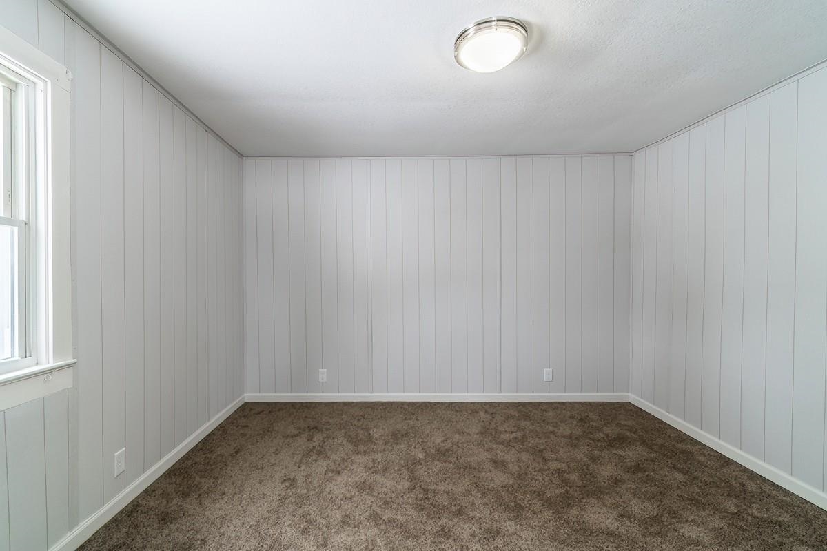 Unfurnished room with dark carpet