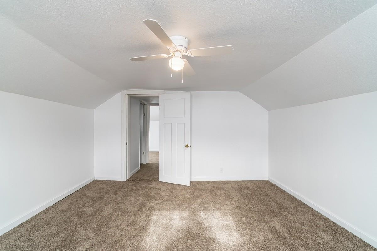 Bonus room with carpet flooring and ceiling fan