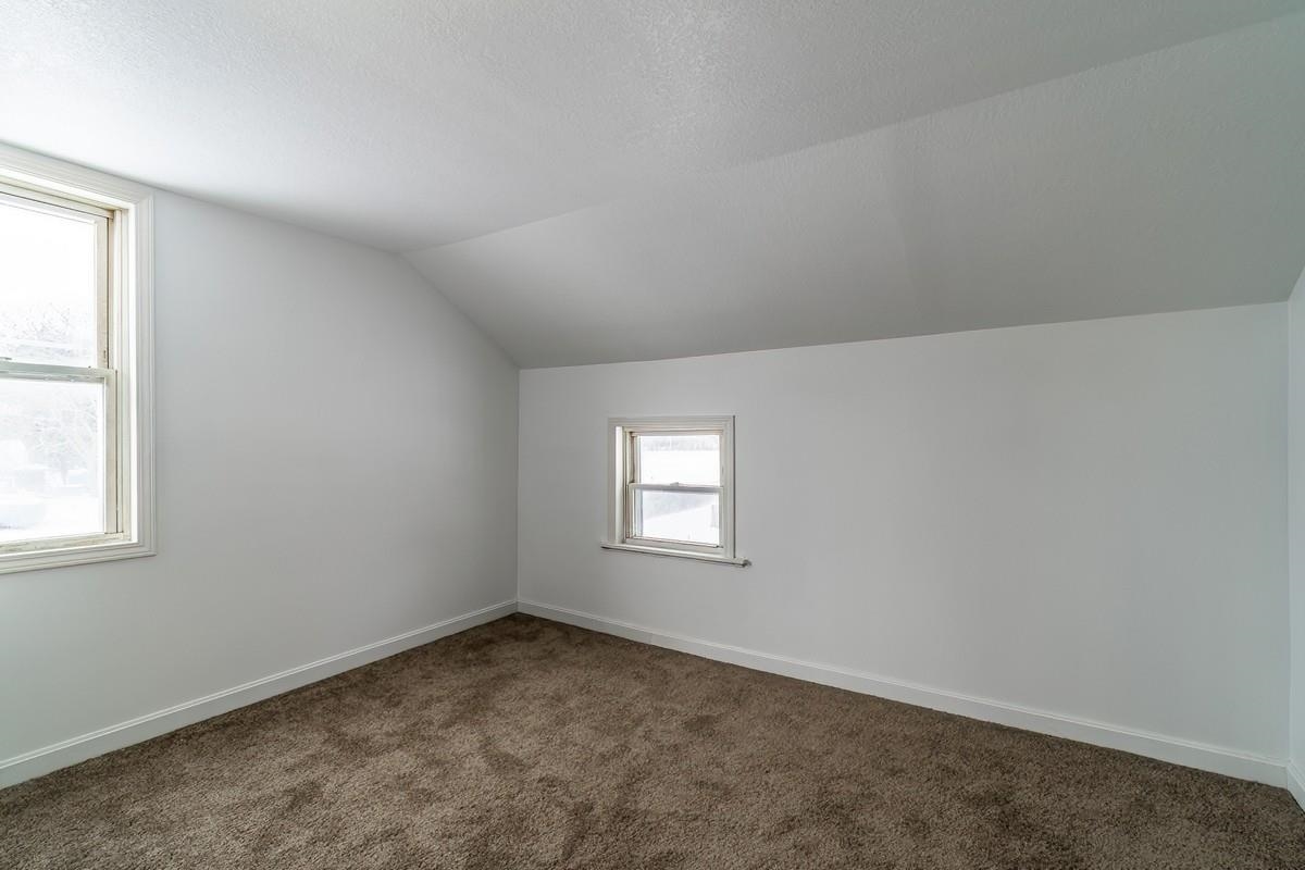 Additional living space featuring baseboards and carpet flooring