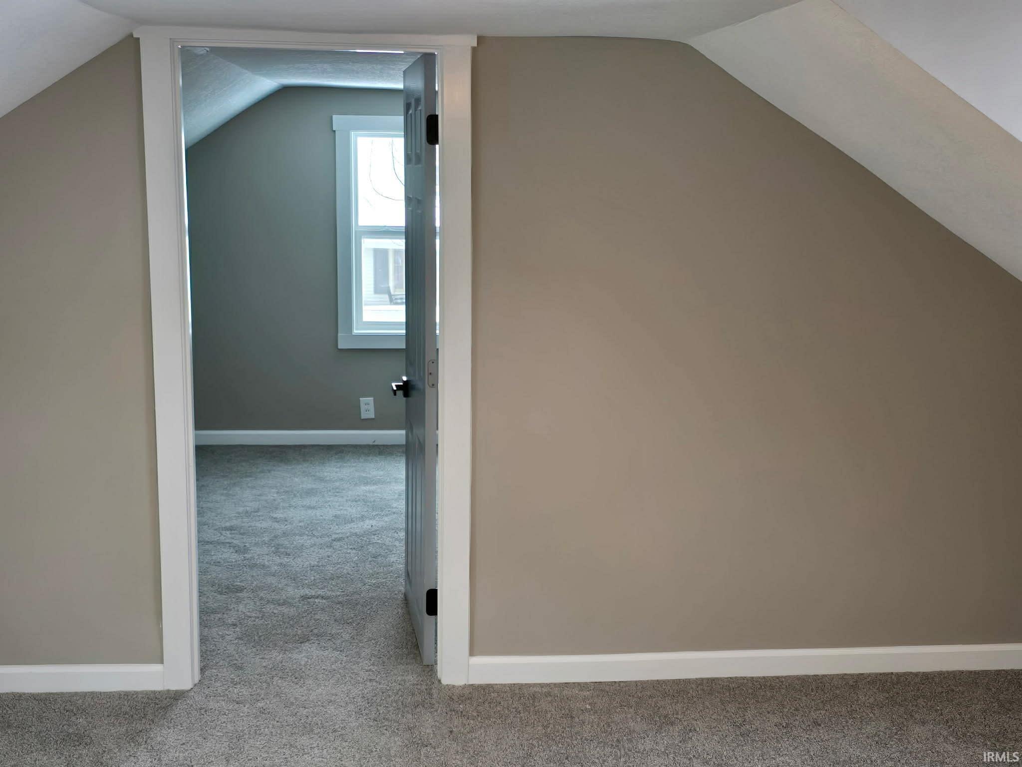 Bonus room with light carpet and lofted ceiling