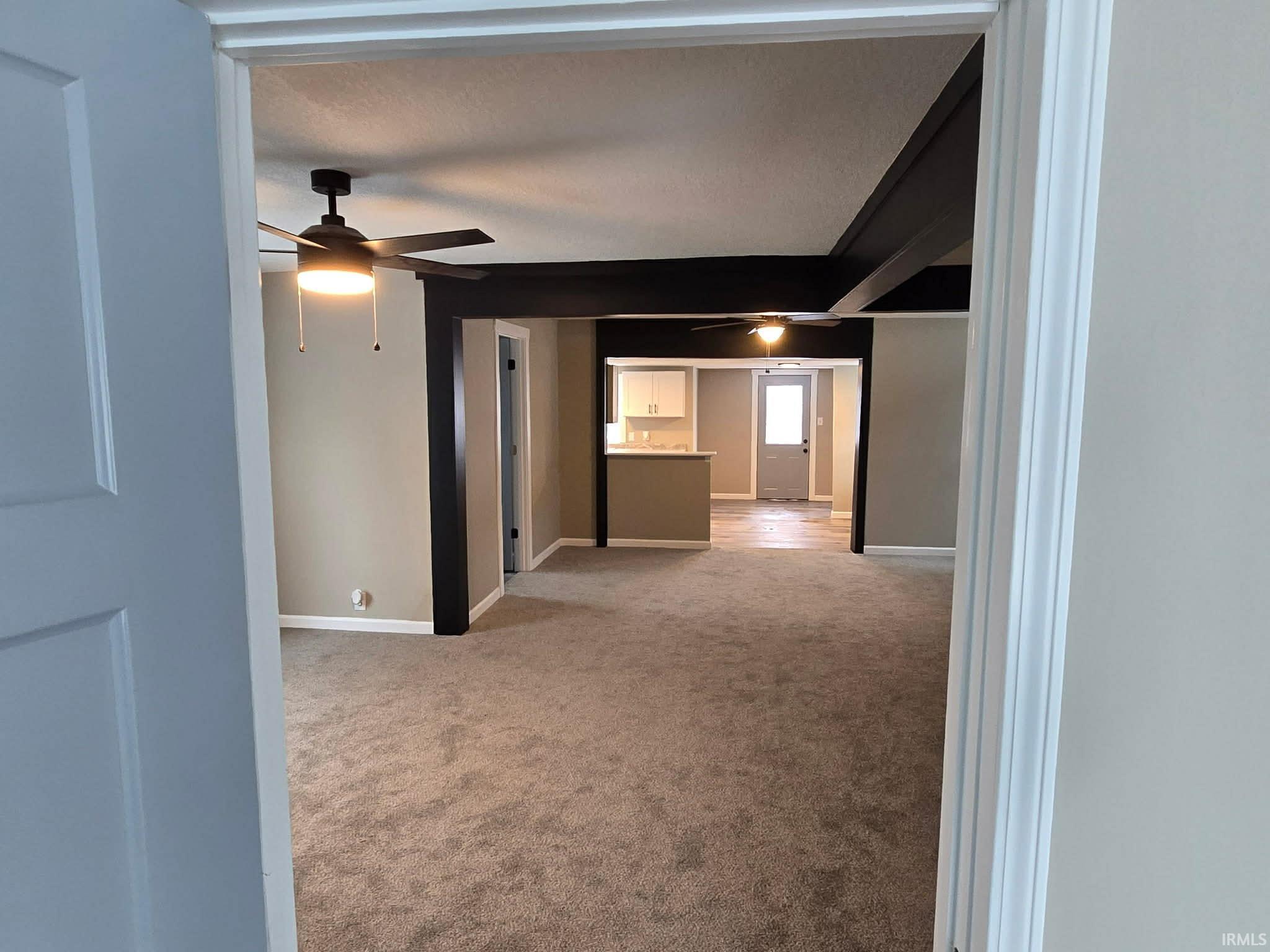 Spare room with light carpet and a ceiling fan