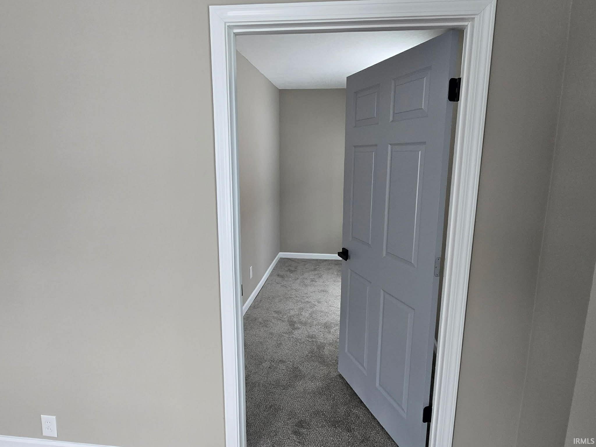 Corridor with carpet flooring and baseboards