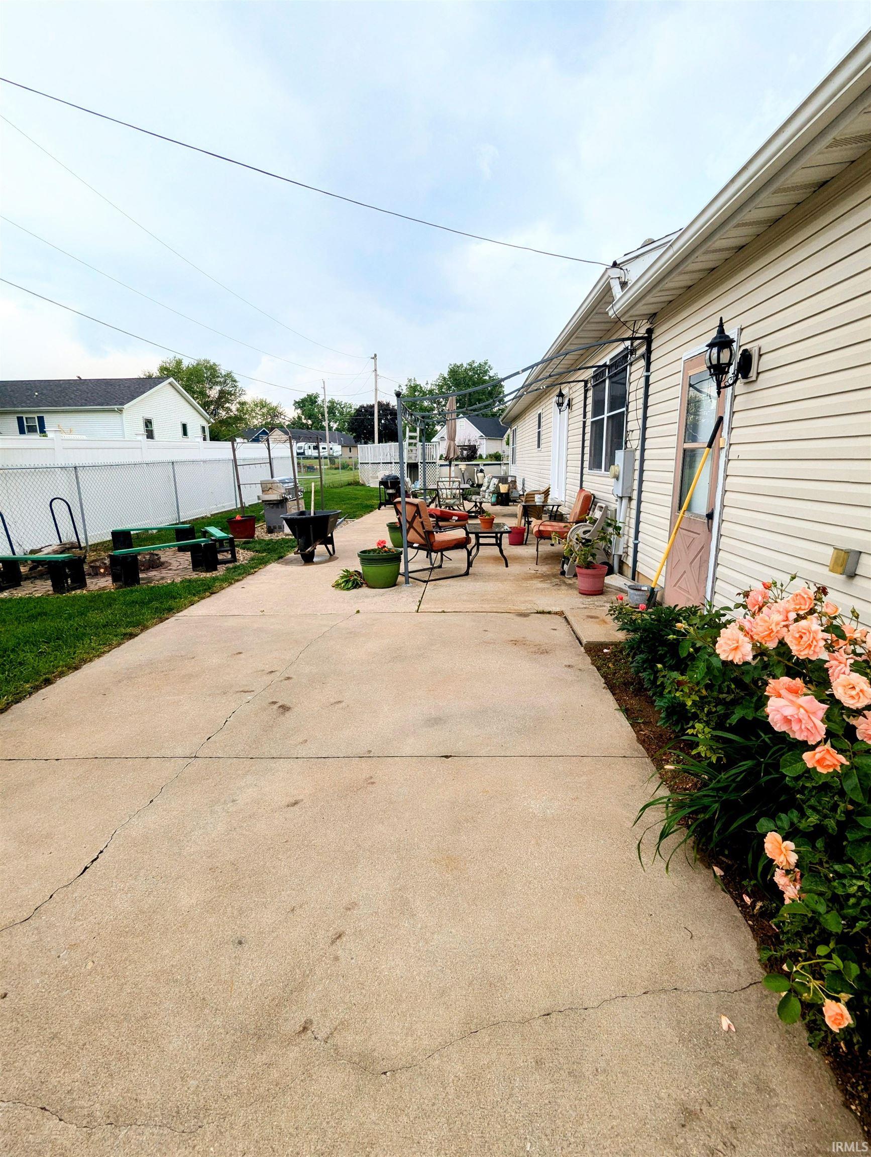Fenced backyard with a concrete patio and pool
