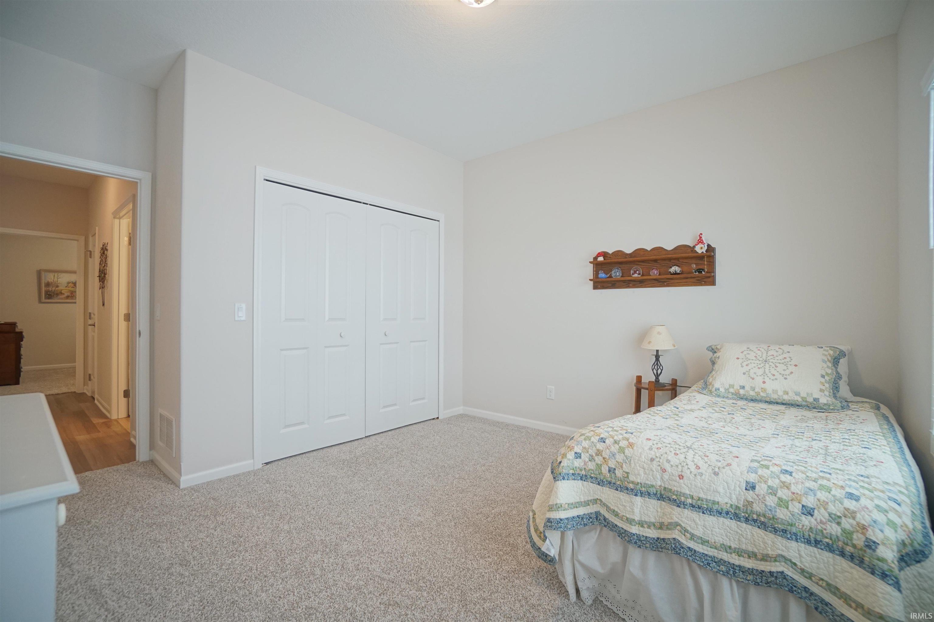 Bedroom featuring light colored carpet and a closet
