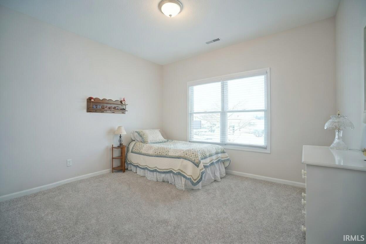 Bedroom featuring baseboards and carpet