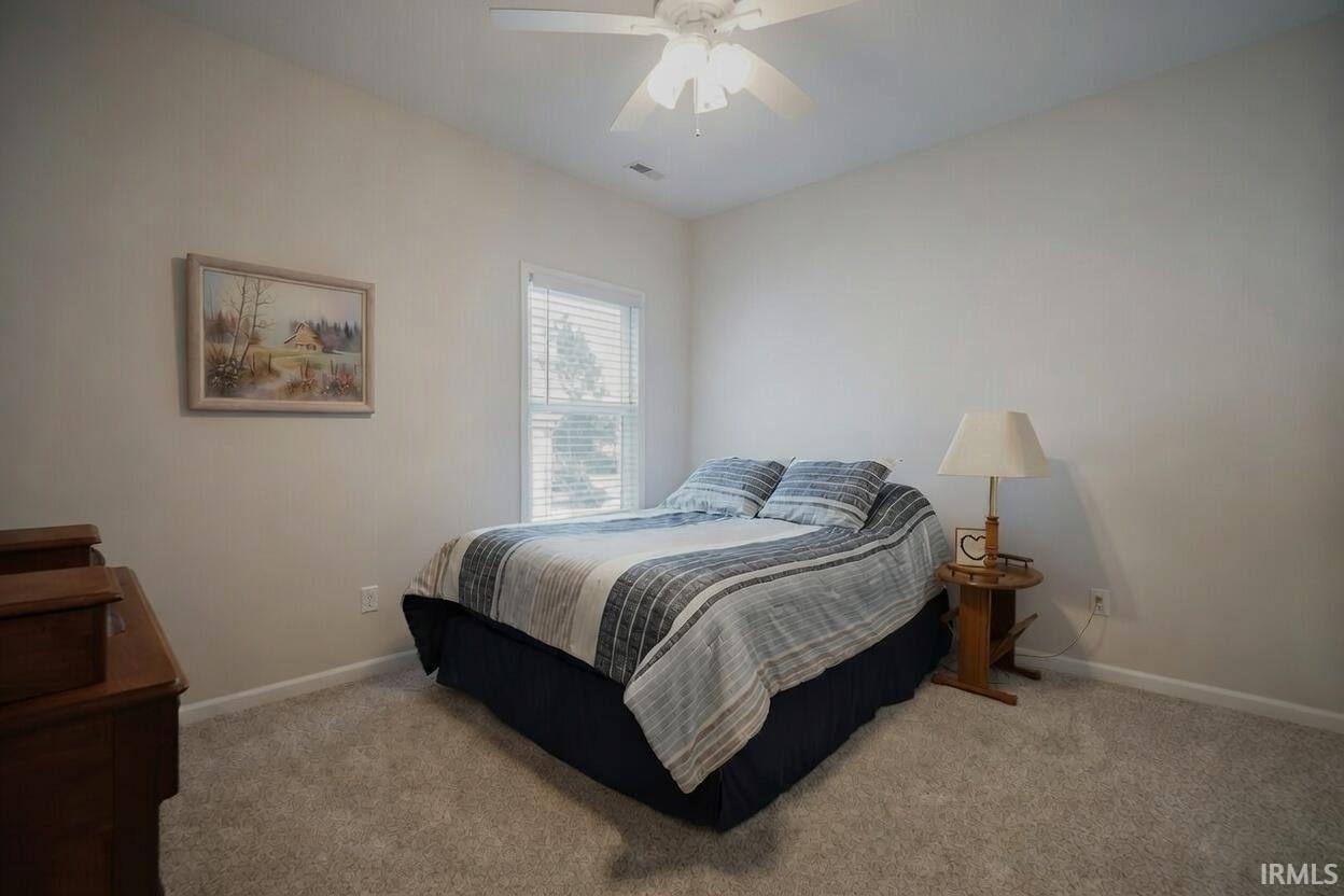 Bedroom with ceiling fan and carpet