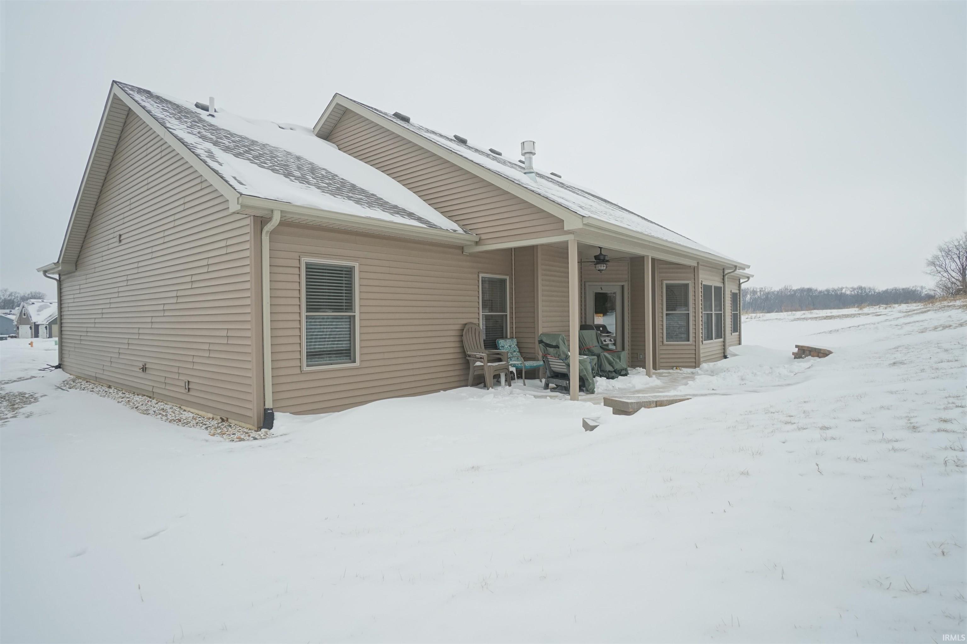 Snow covered rear of property featuring a patio and ceiling fan