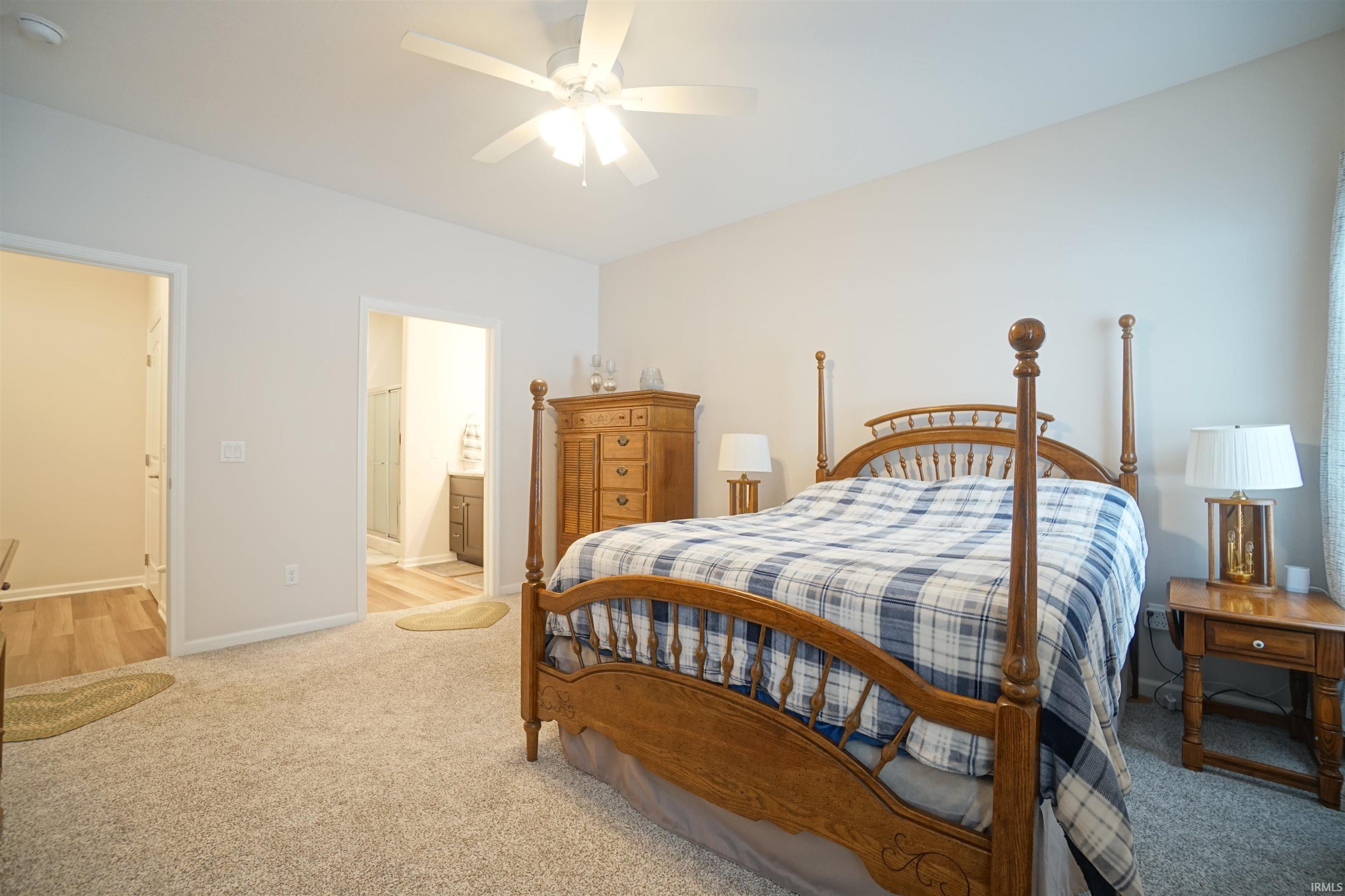 Bedroom with carpet flooring, a ceiling fan, and ensuite bathroom