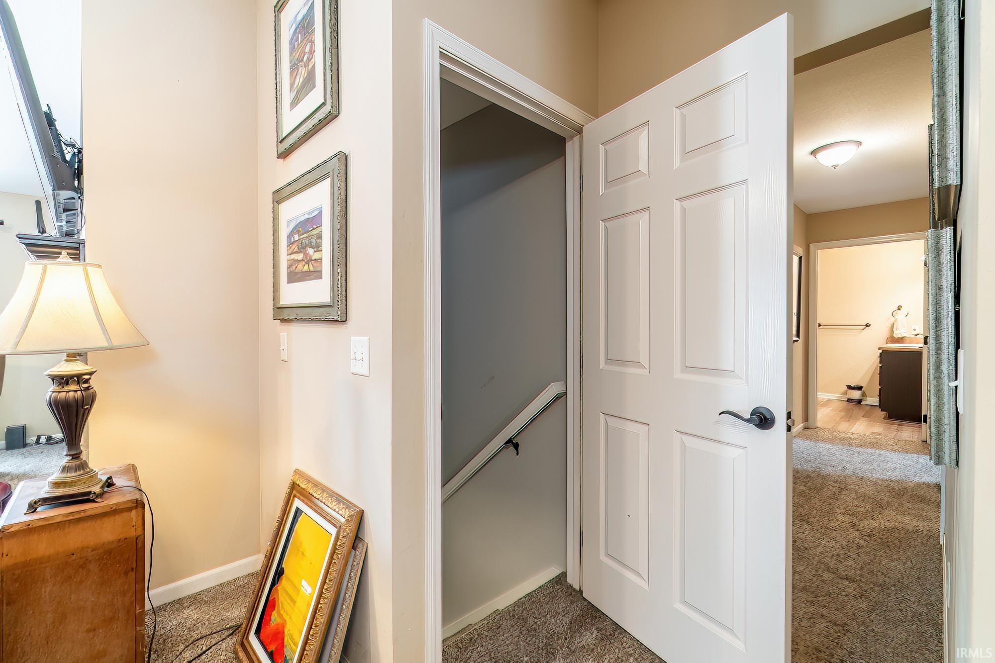 Hall with carpet and an upstairs landing