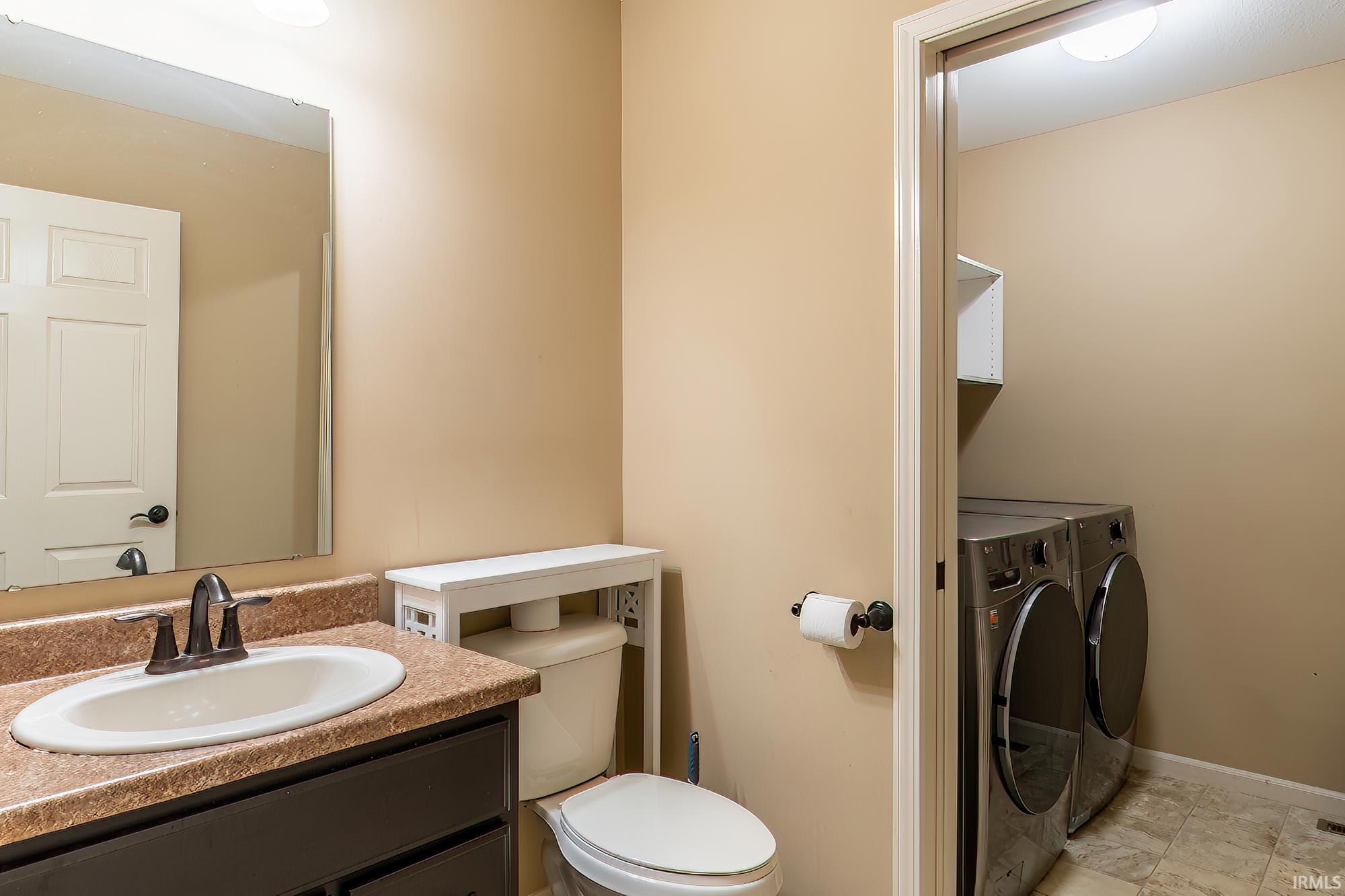 Half bath featuring separate washer and dryer and vanity
