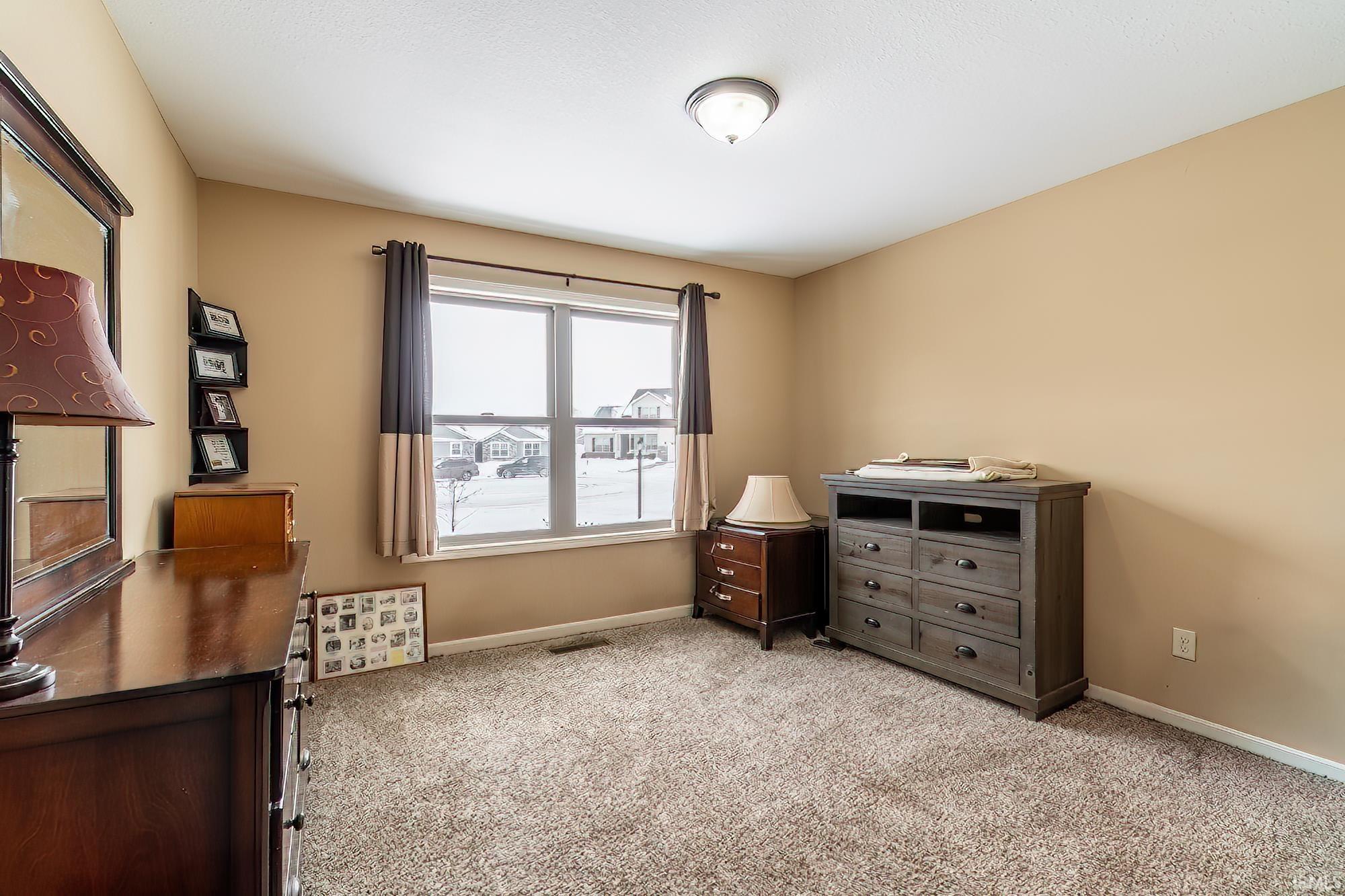 Bedroom with light carpet and baseboards