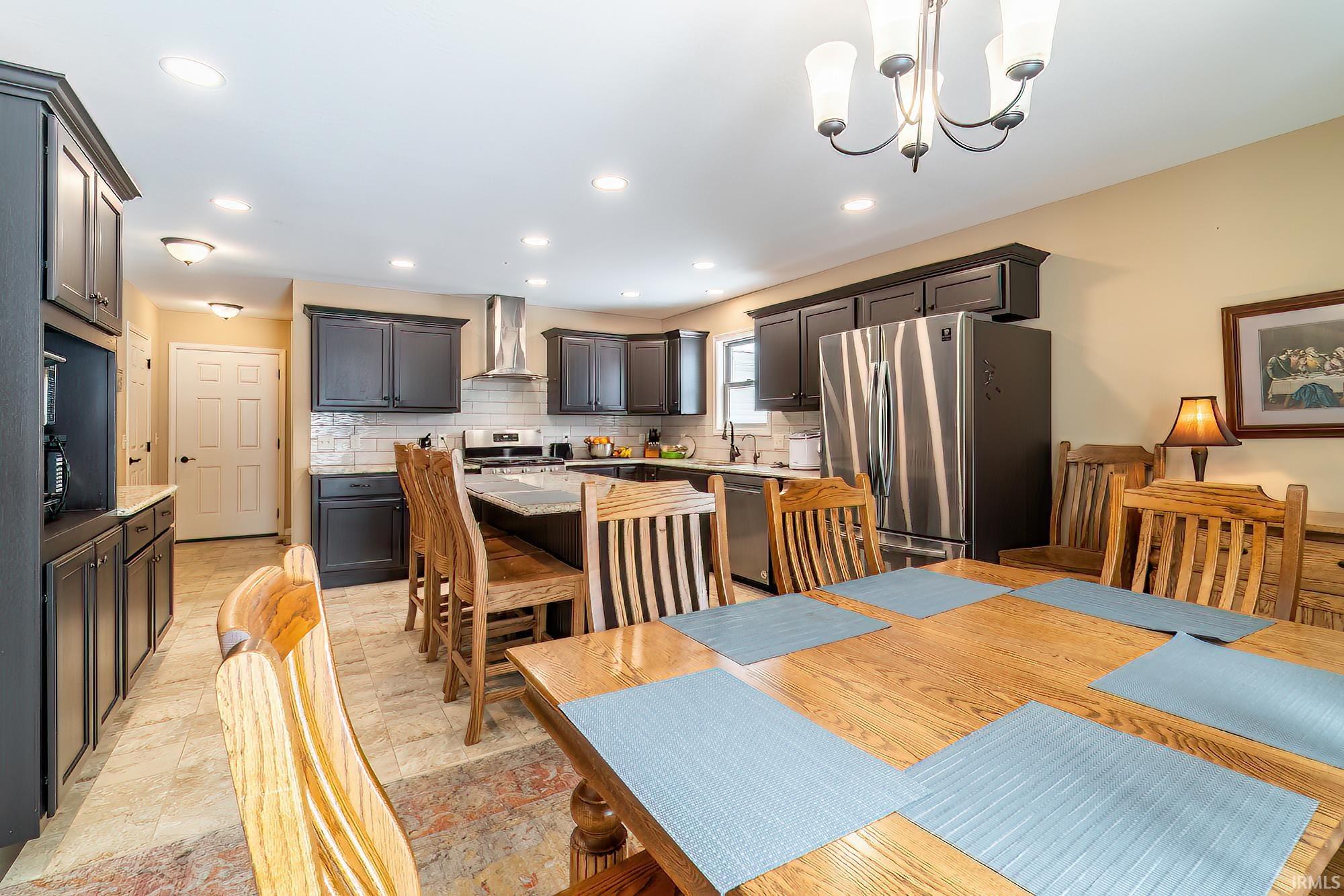 Dining area featuring hanging lights and light stone finish flooring