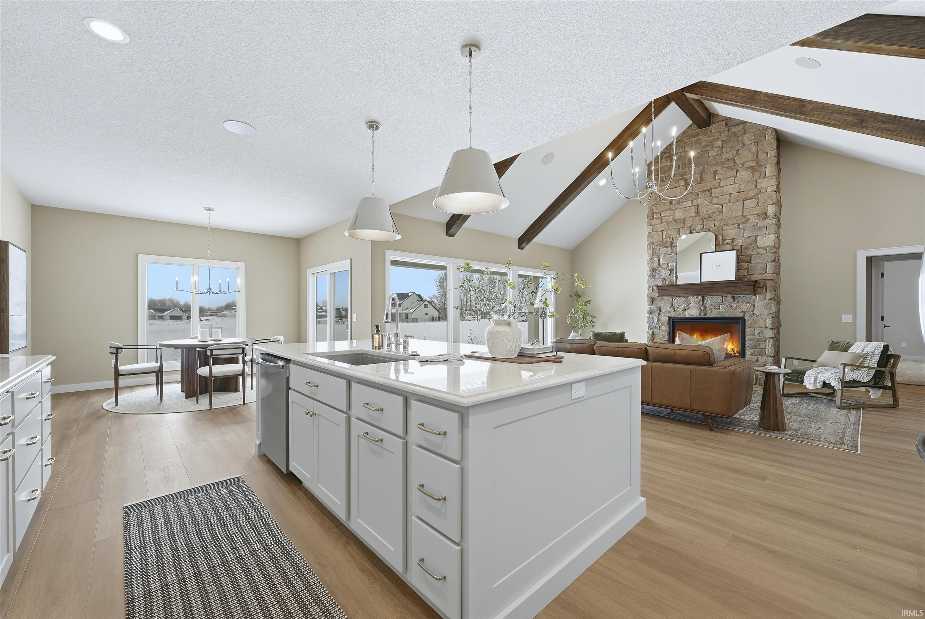 Kitchen with a chandelier, white cabinetry, and light wood-style flooring