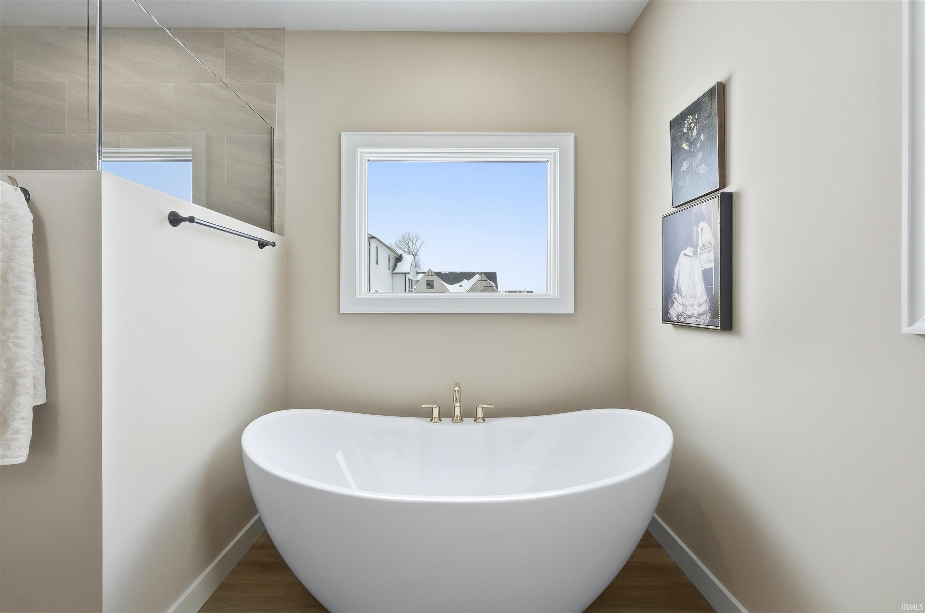 Bathroom with wood finished floors and a soaking tub