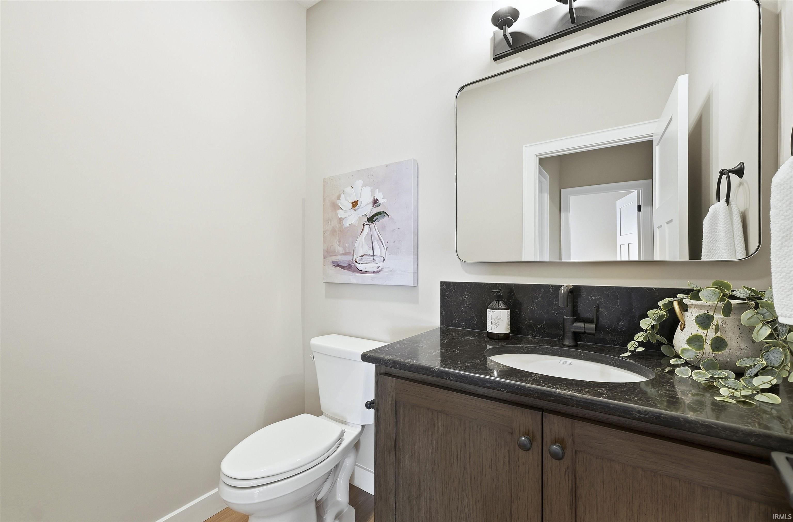 Half bathroom with vanity and toilet