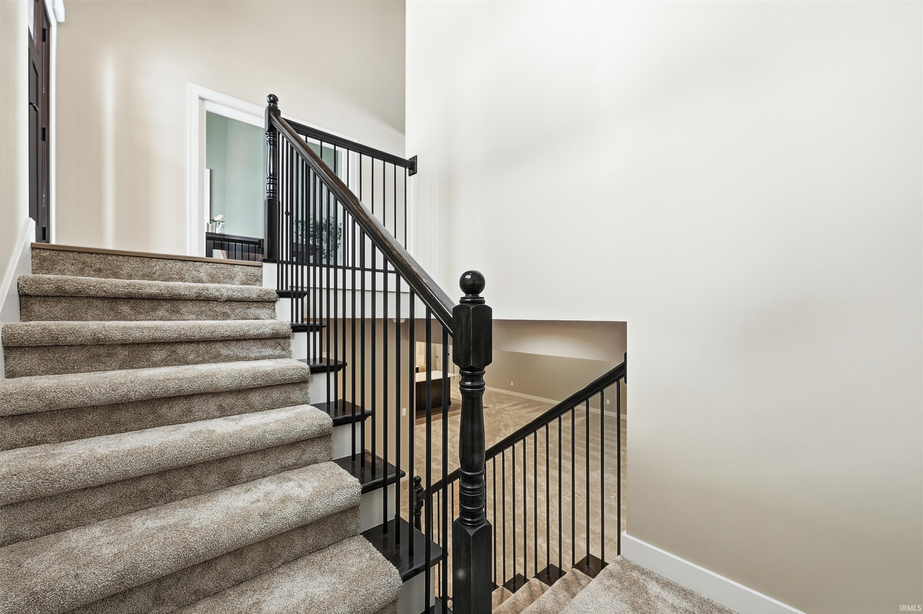 Stairway featuring carpet flooring and a high ceiling