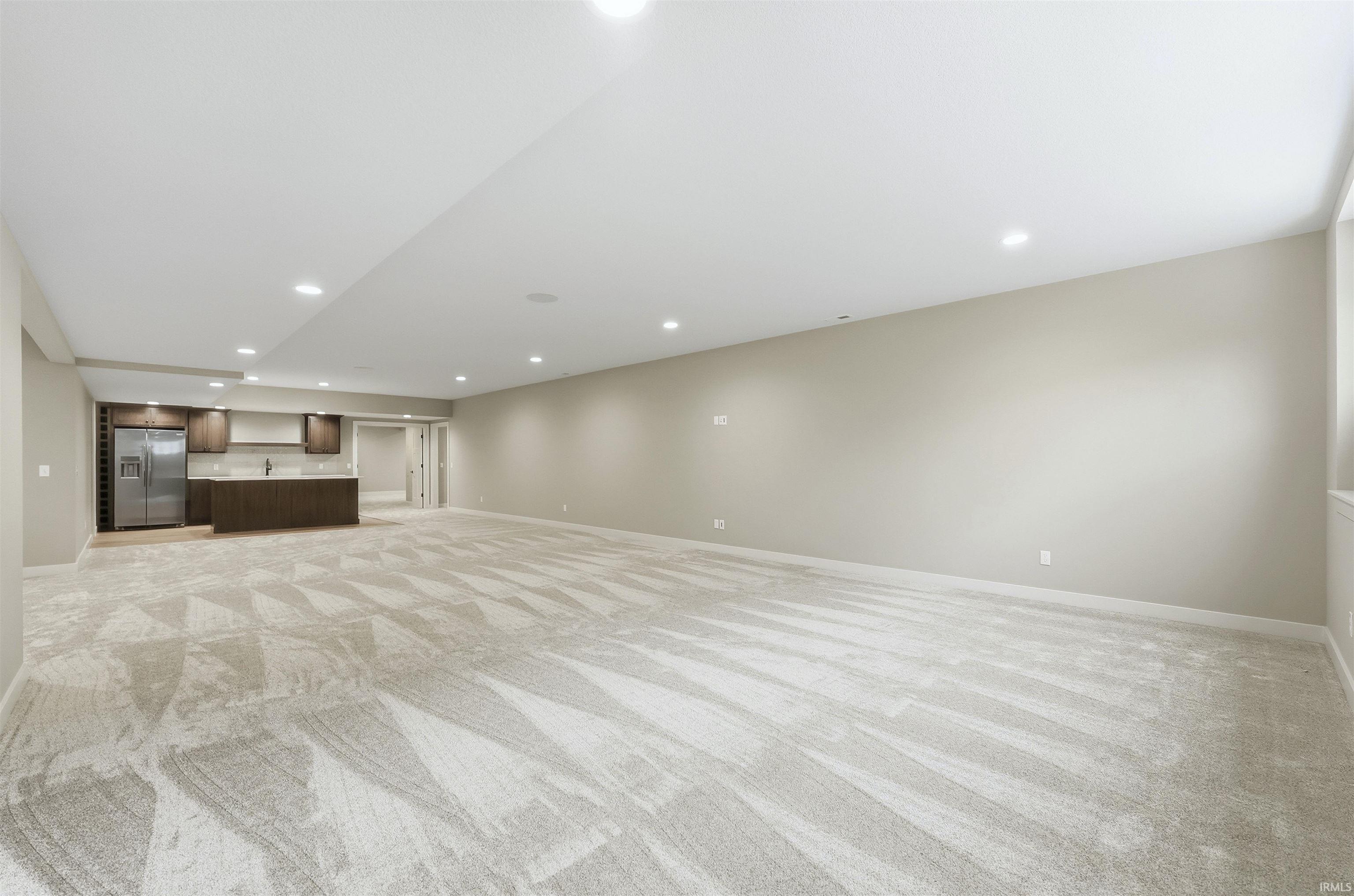 Unfurnished living room featuring recessed lighting and light colored carpet