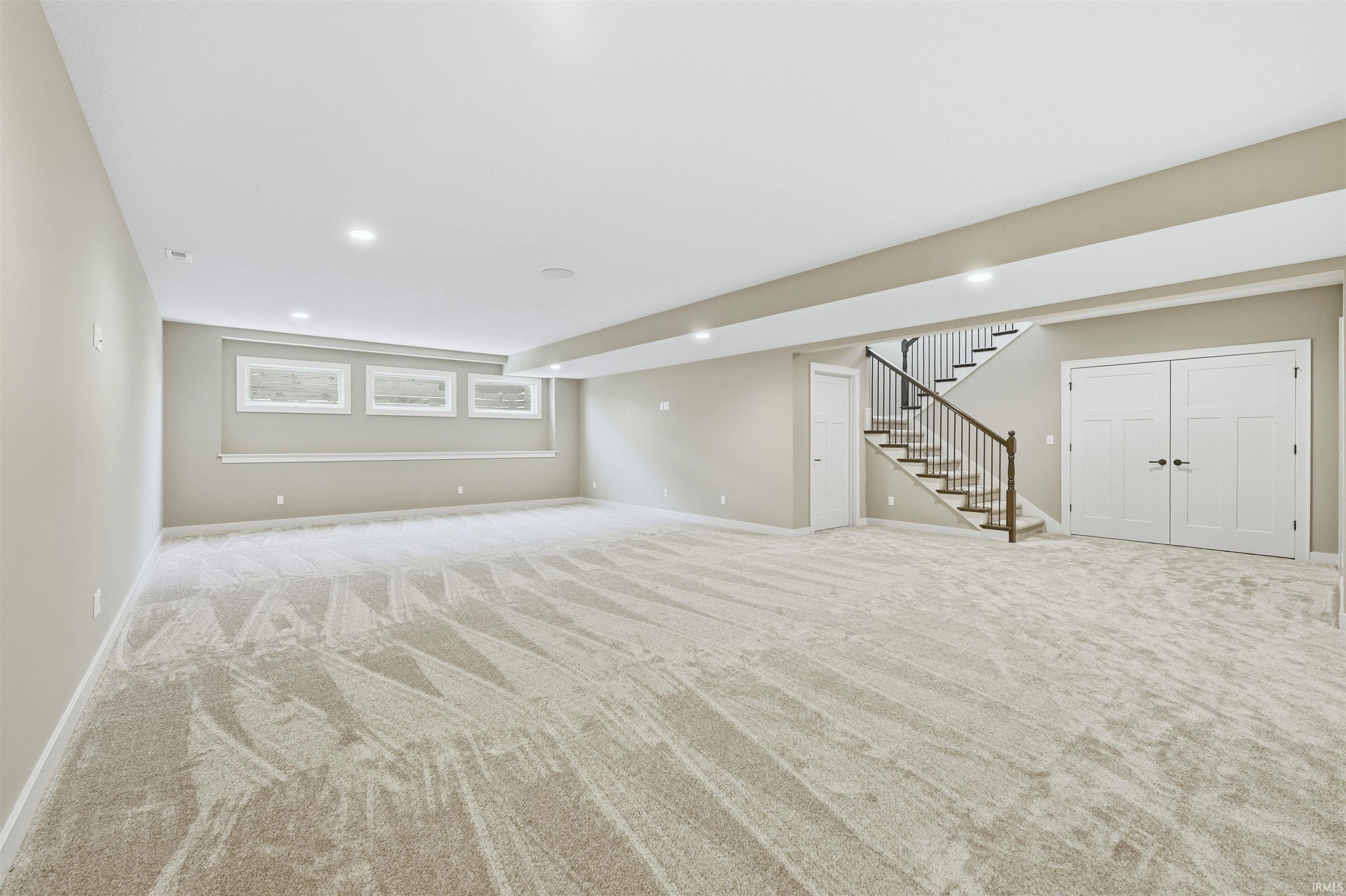 Basement with recessed lighting and light carpet