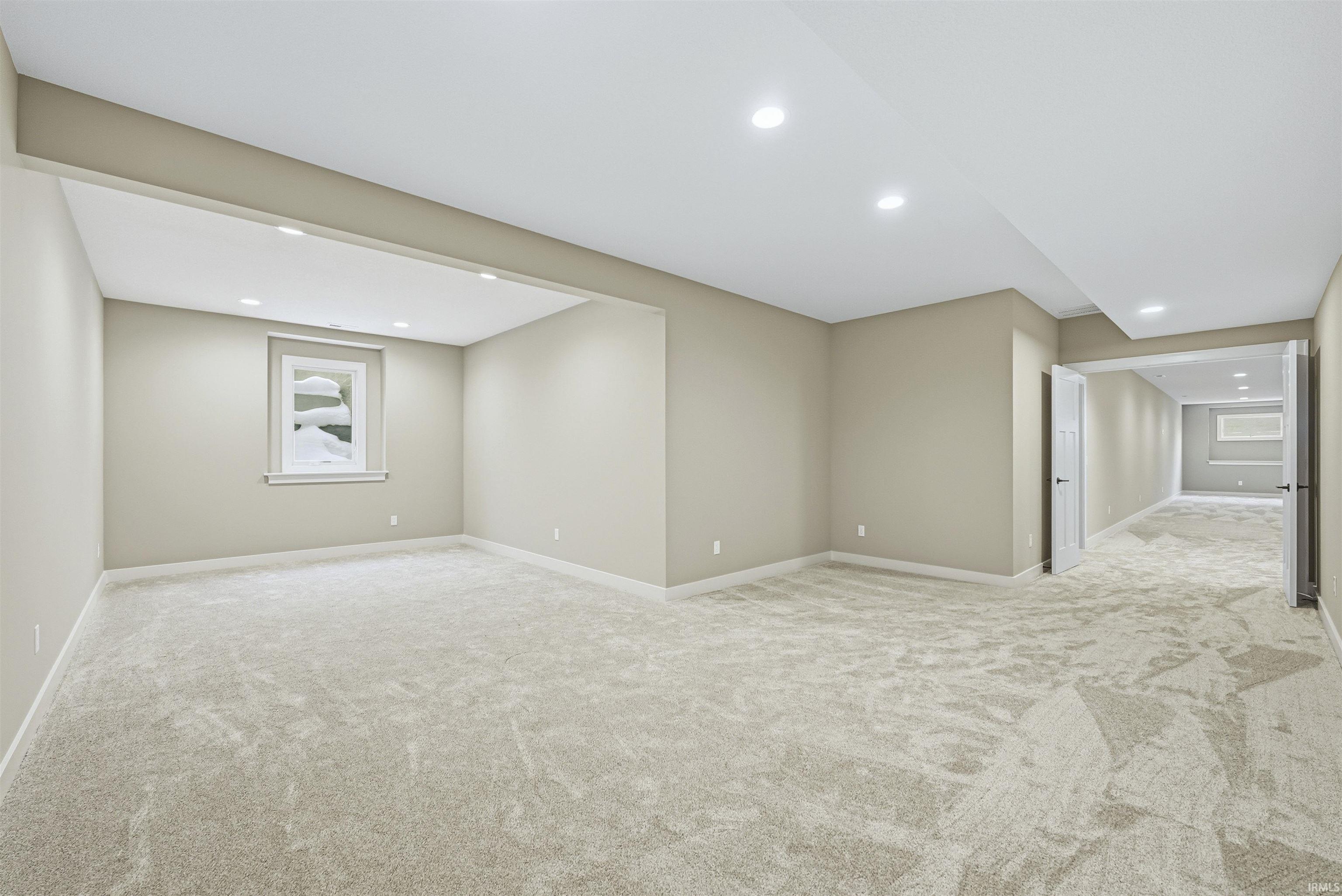 Below grade area with light colored carpet and recessed lighting
