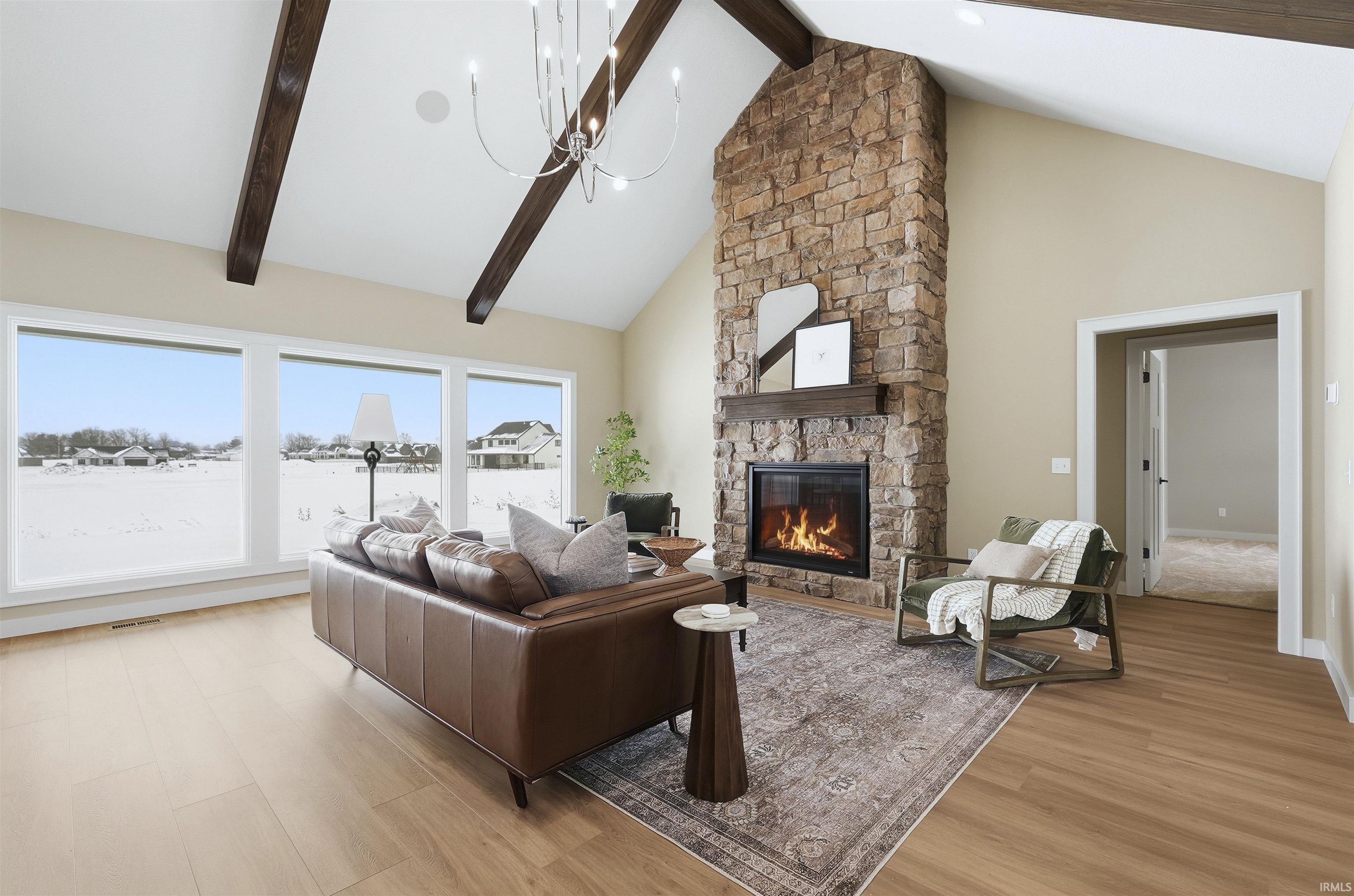 Living area with light wood finished floors, a fireplace, and hanging lights