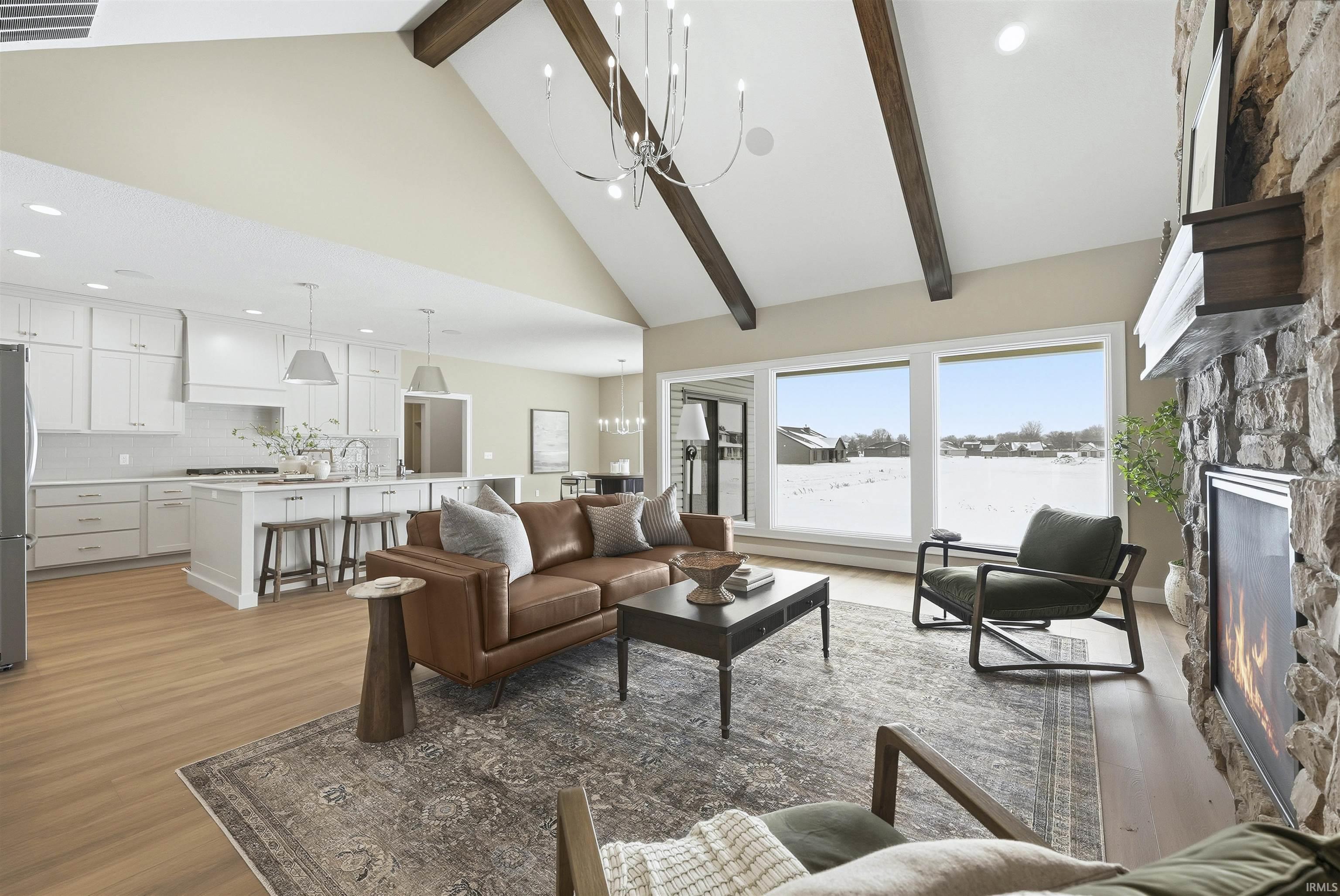 Living area with suspended lighting, a fireplace, and light wood finished floors
