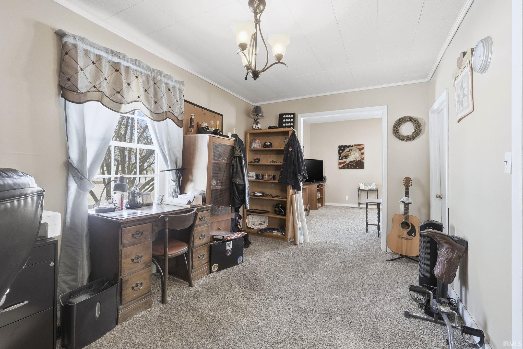 Carpeted office with suspended lighting and ornamental molding