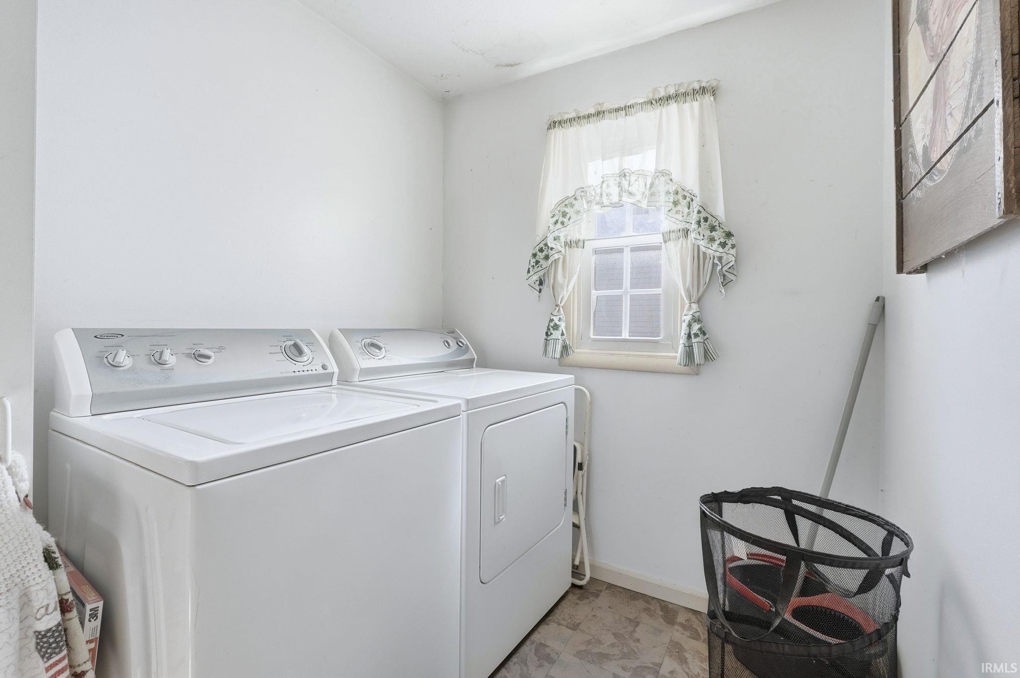 Laundry area featuring independent washer and dryer and baseboards
