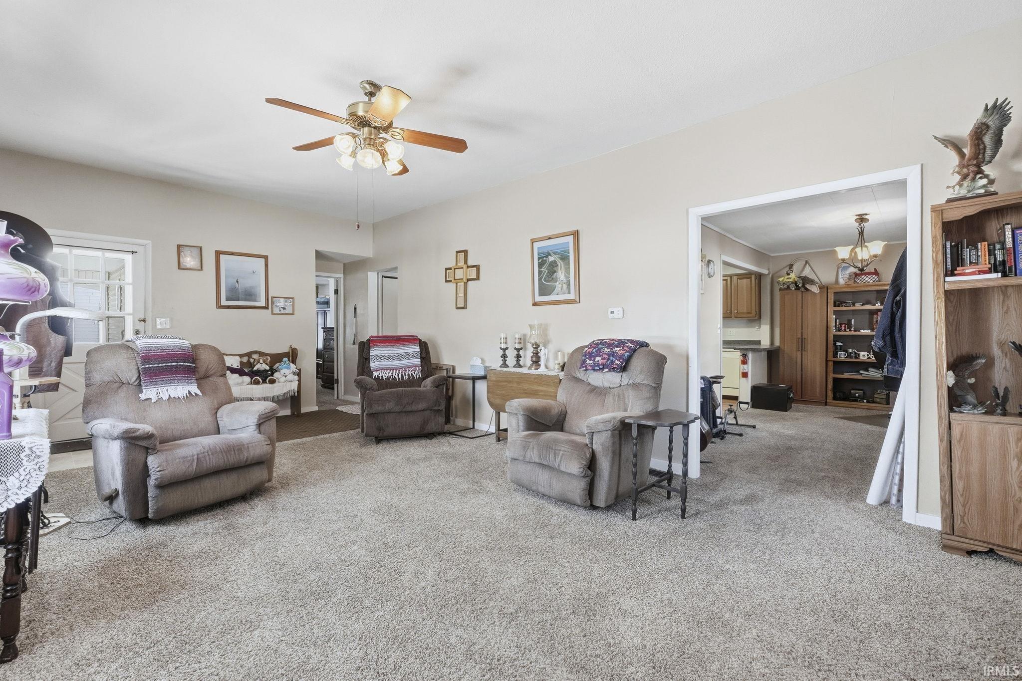 Living room featuring a ceiling fan and light colored carpet