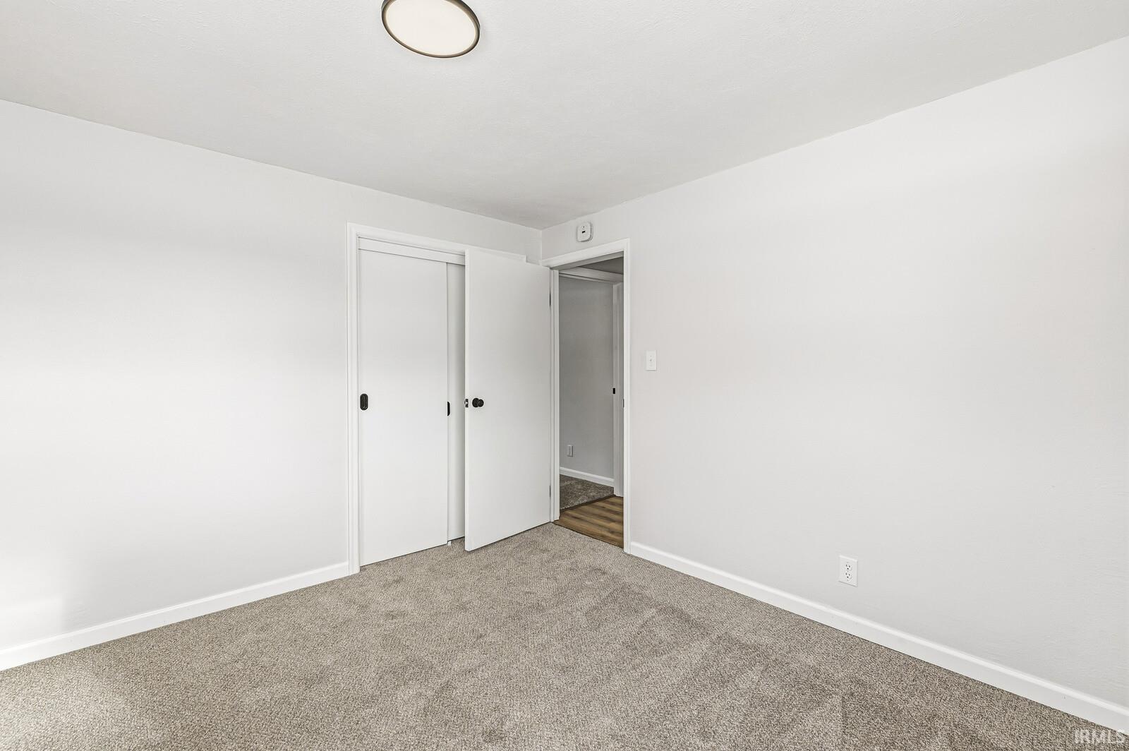 Unfurnished room with carpet and baseboards