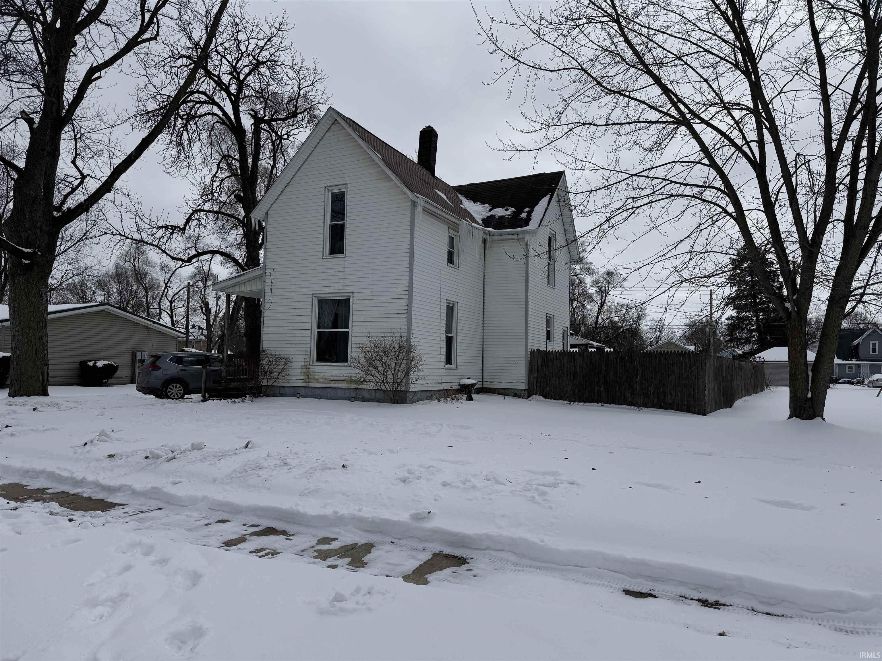 View of snow covered exterior with a chimney