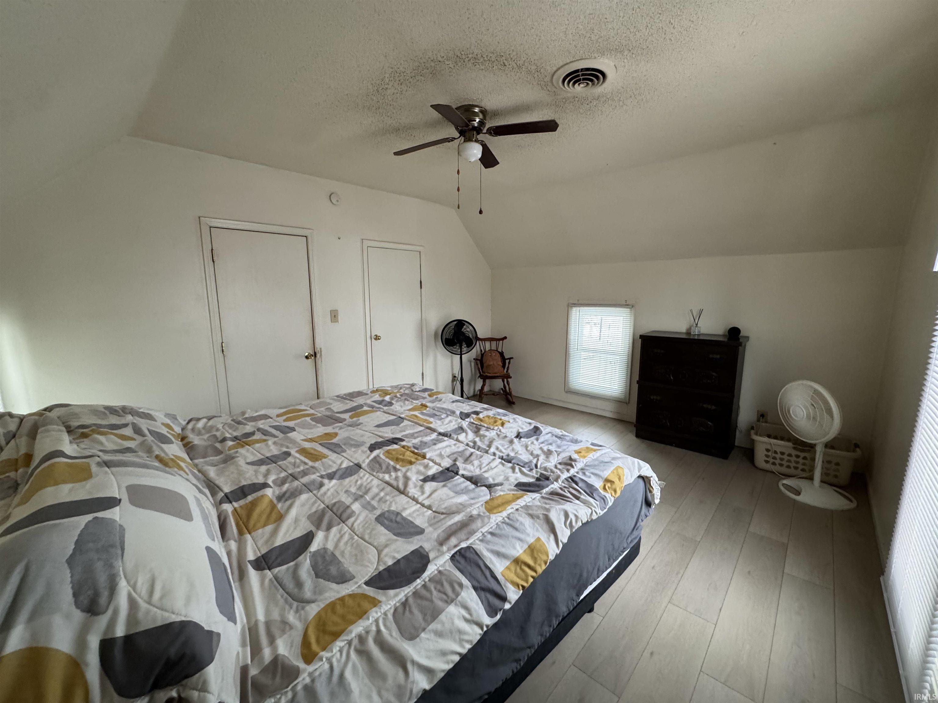 Bedroom with light wood finished floors and a ceiling fan