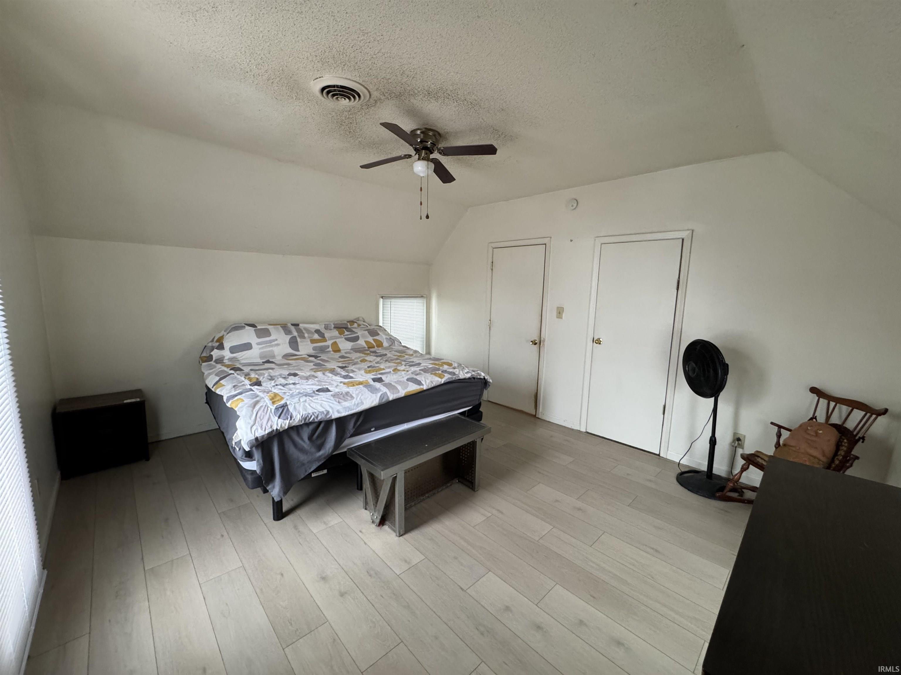 Bedroom with light wood-style floors and a ceiling fan