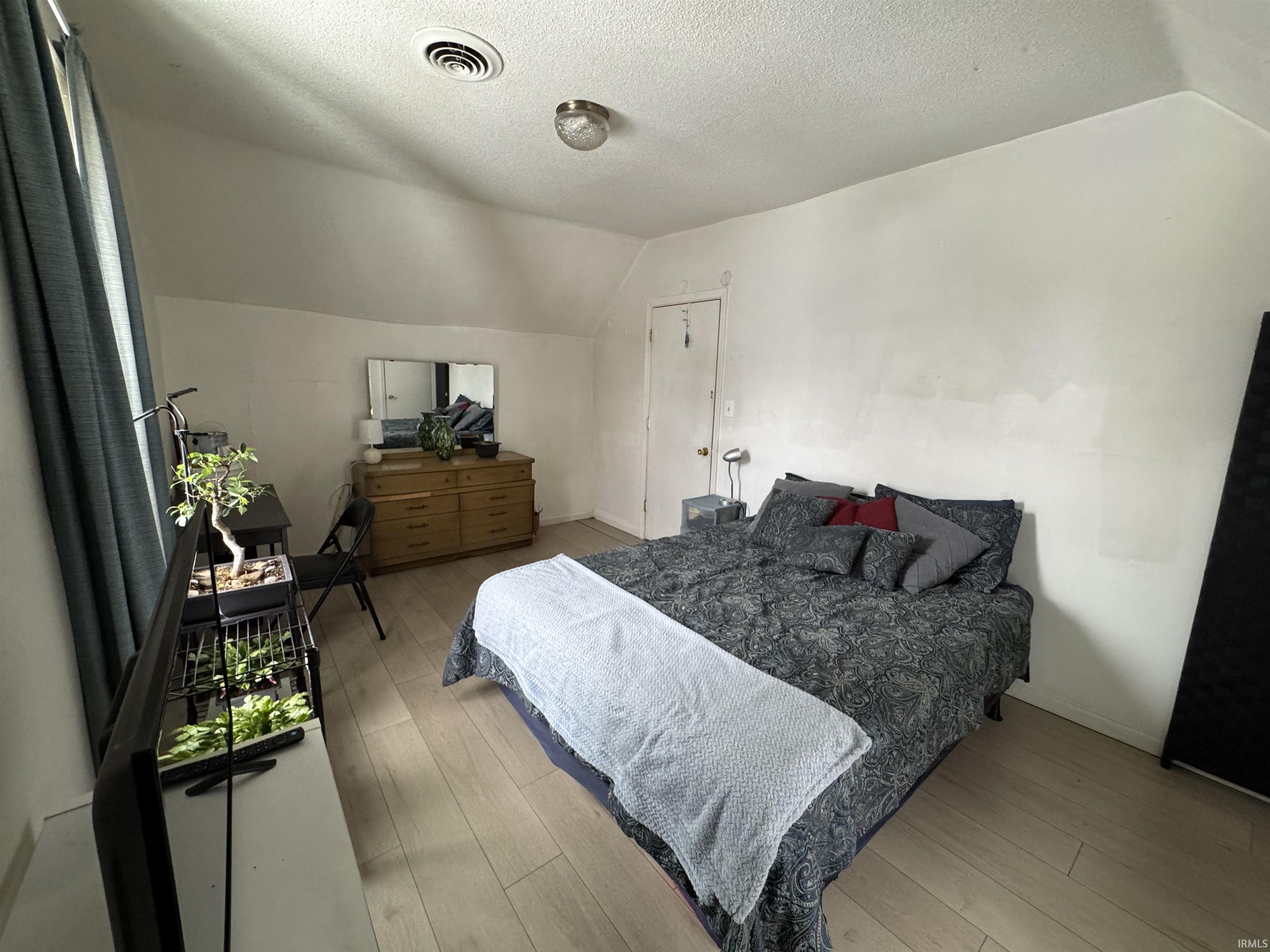 Bedroom with light wood-style flooring and baseboards
