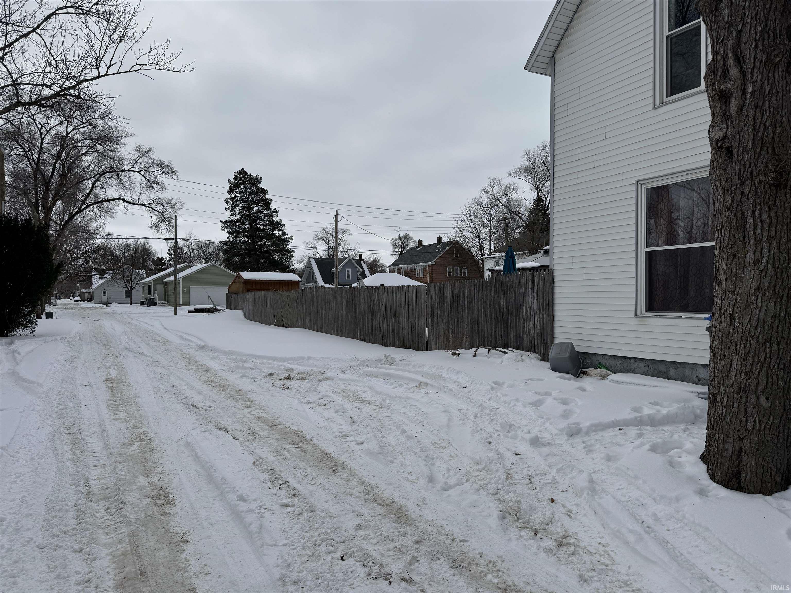Yard layered in snow with a residential view