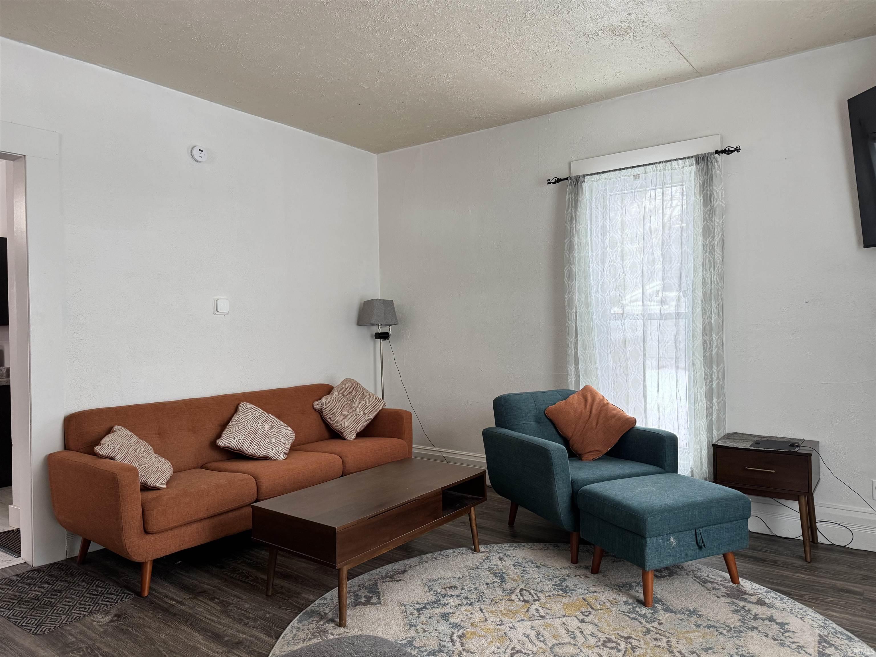Living room featuring a textured ceiling and wood finished floors
