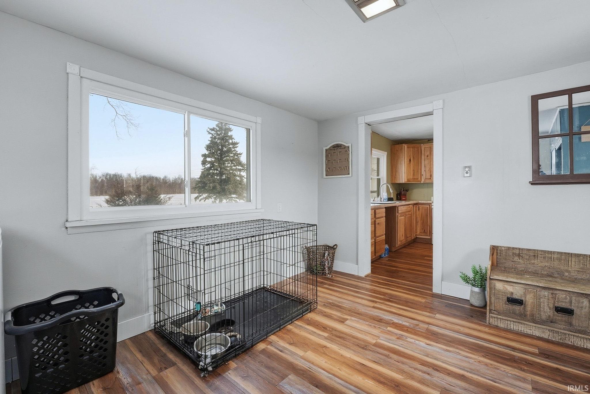 Living room featuring dark wood-type flooring and baseboards