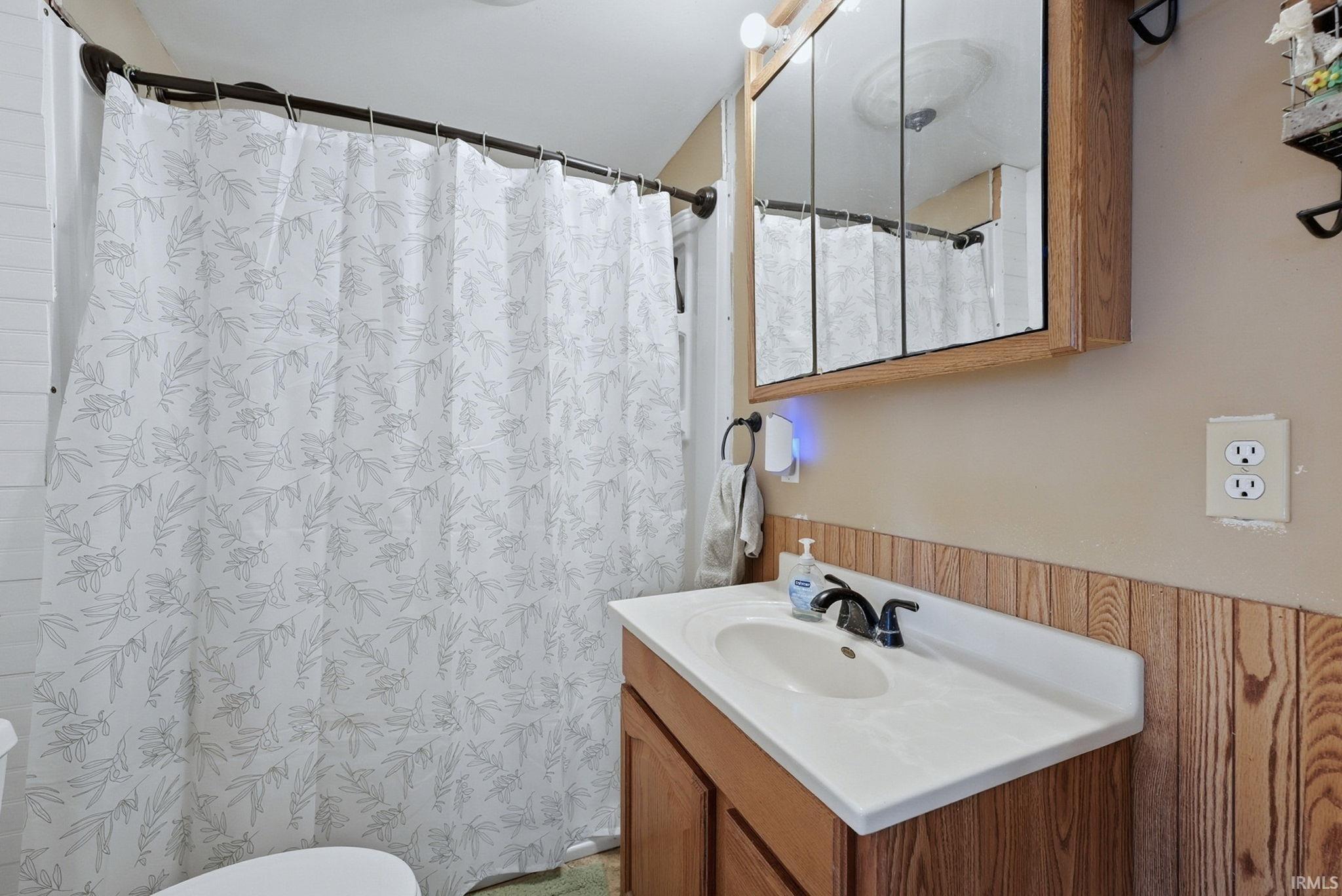 Full bathroom featuring a shower with shower curtain and vanity