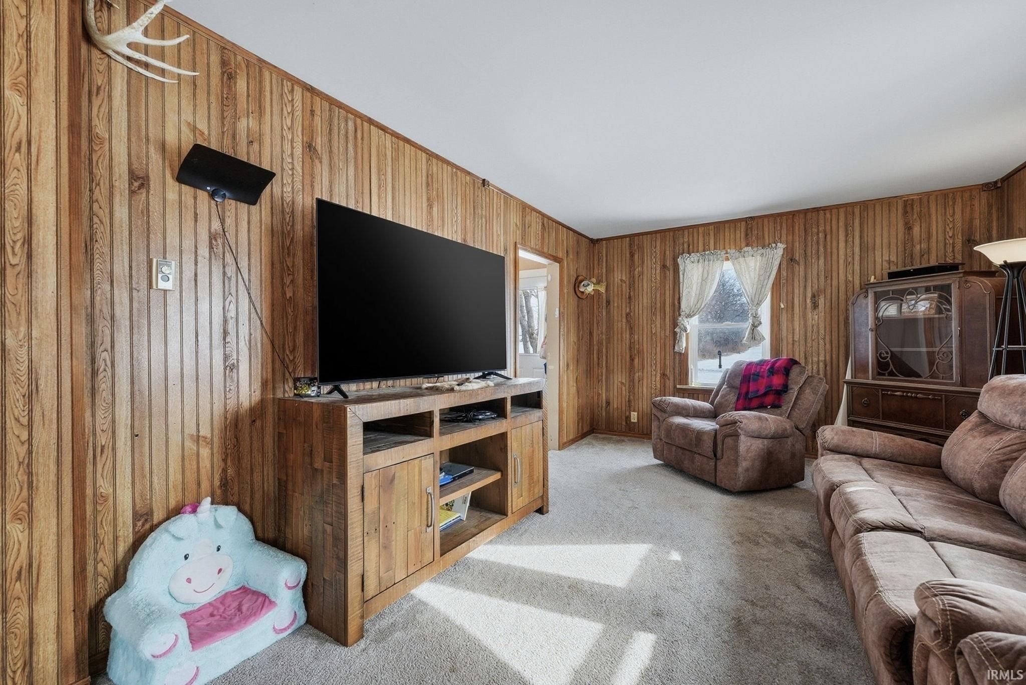 Living area with carpet and wooden walls