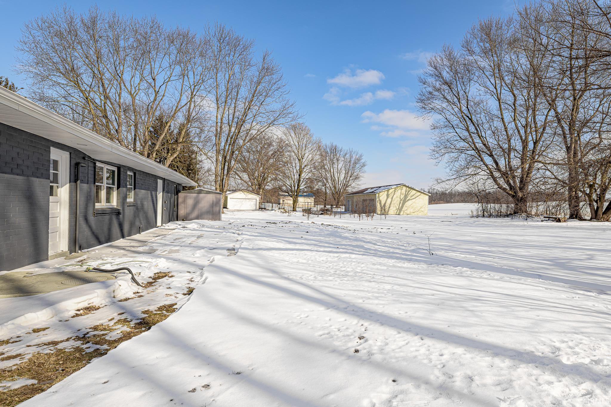 Snowy yard featuring an outbuilding