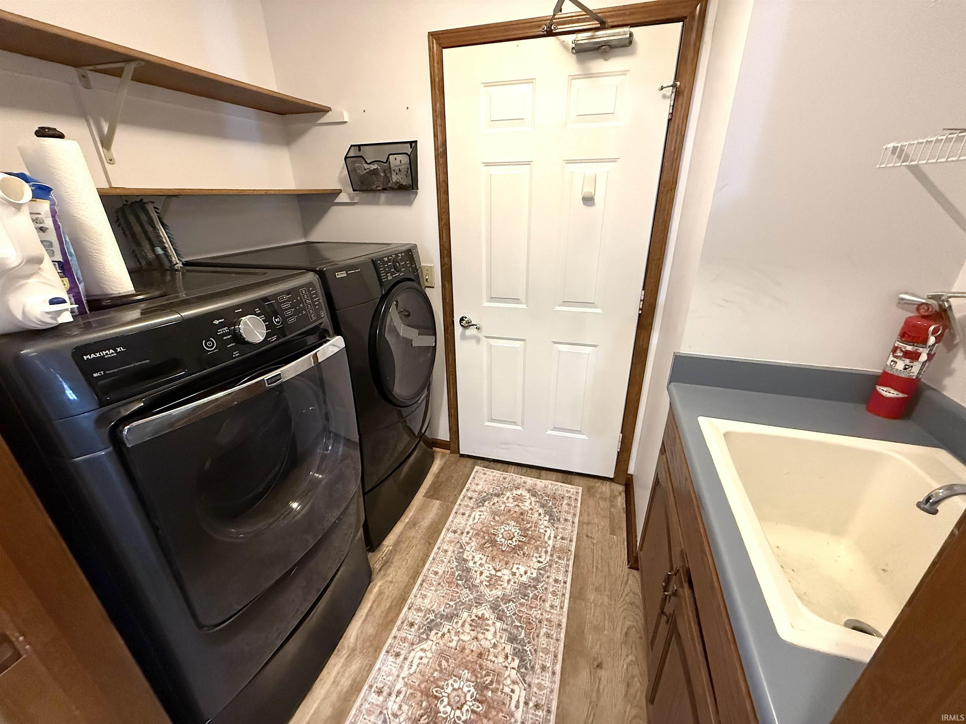Laundry area with light wood-style floors and independent washer and dryer