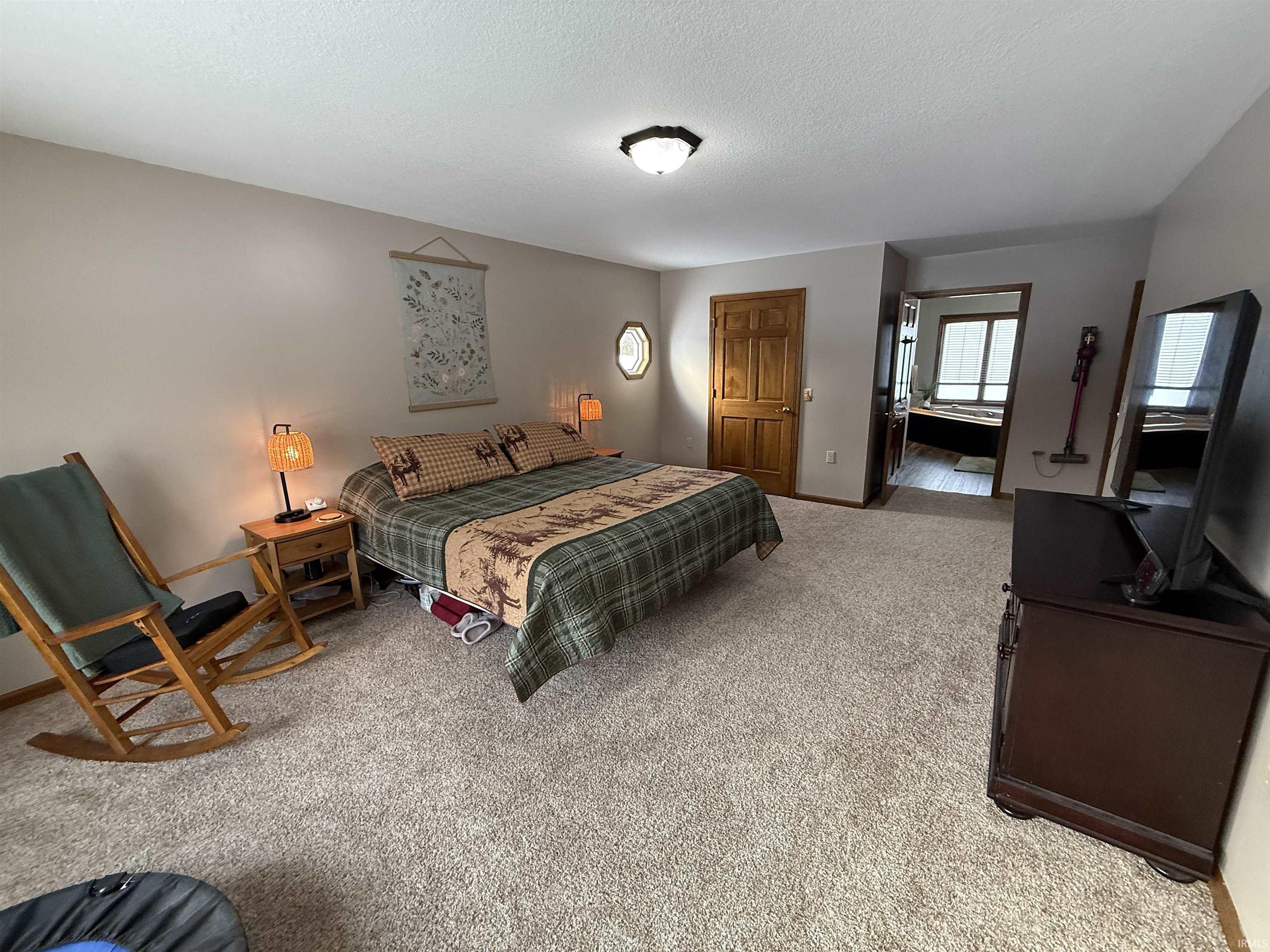 Bedroom featuring light carpet and a textured ceiling