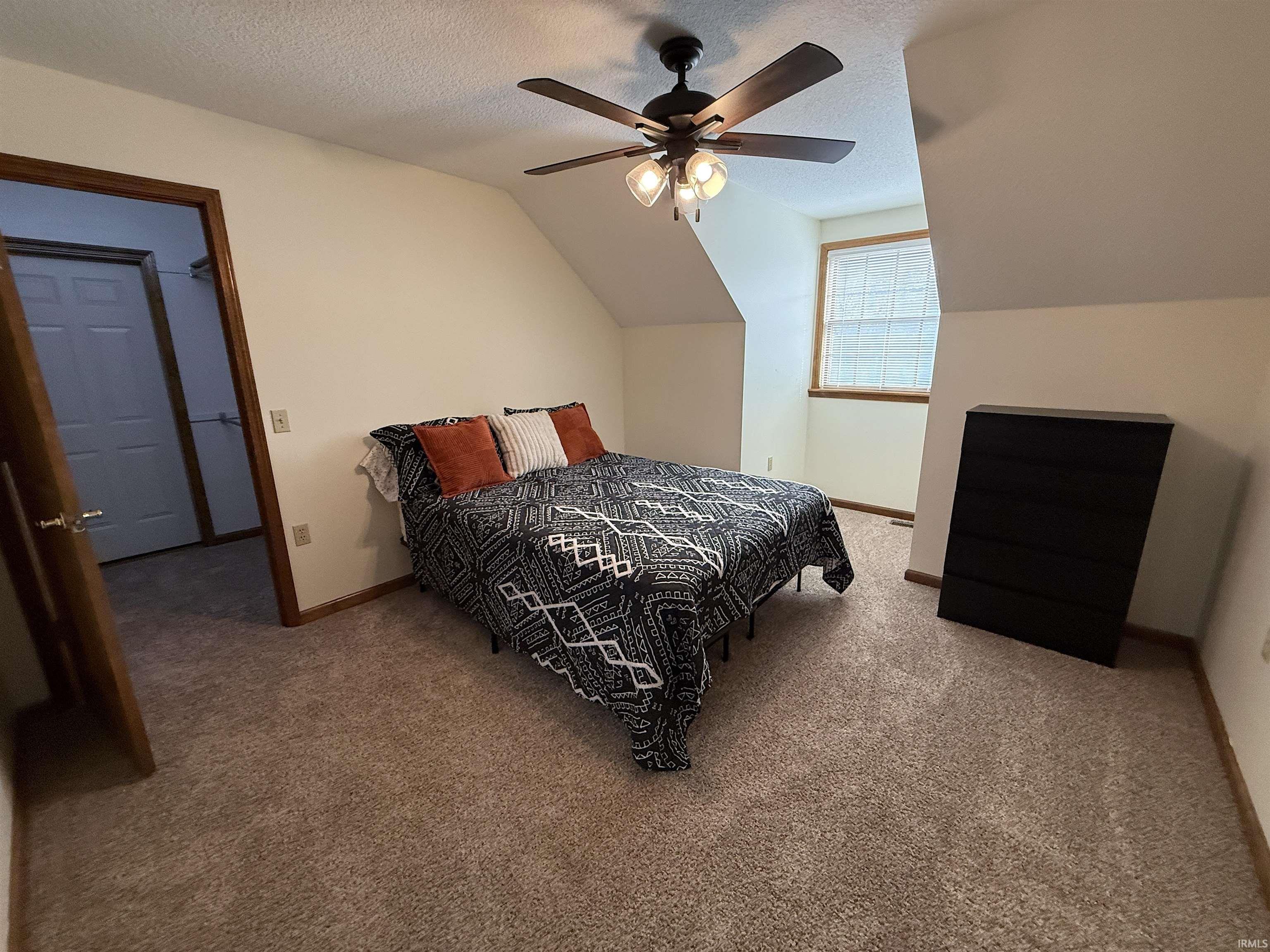 Carpeted bedroom featuring baseboards and a ceiling fan