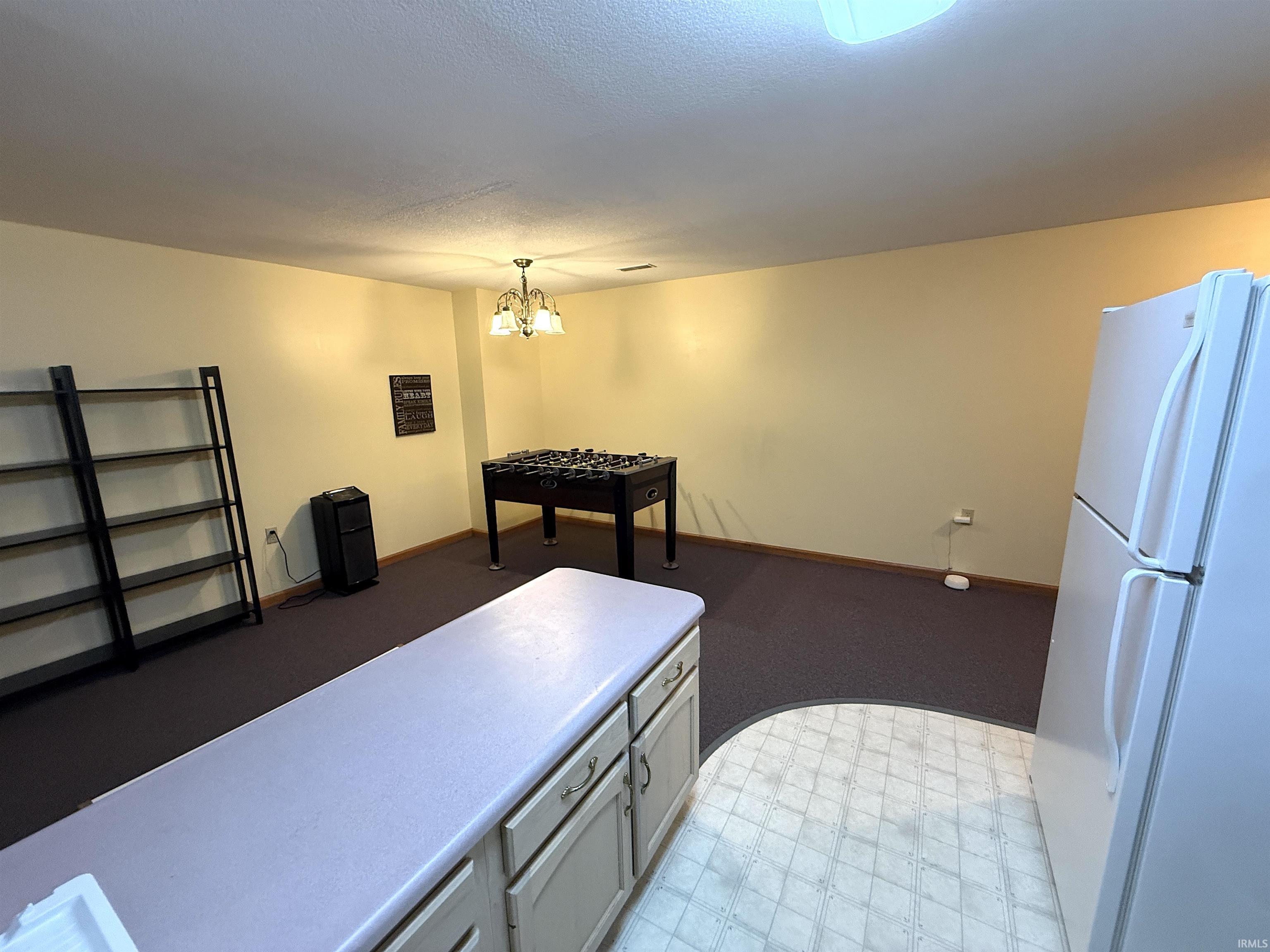 Recreation room featuring light flooring and hanging lights