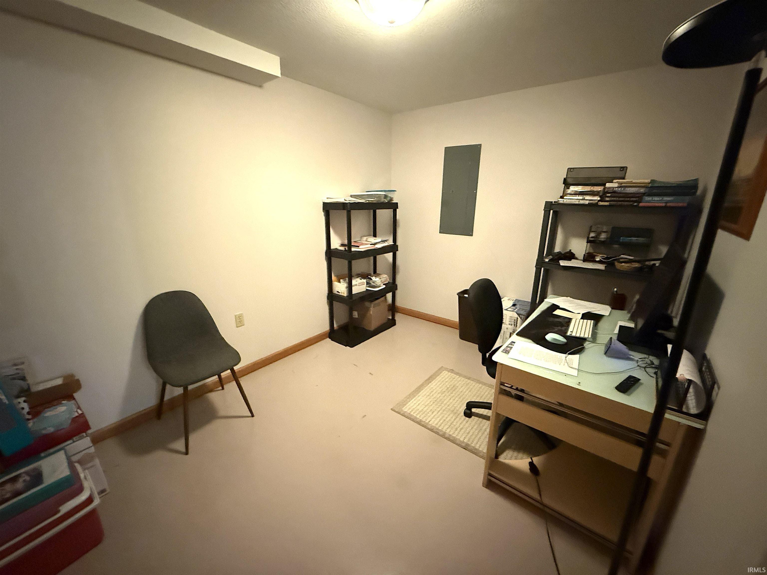 Office space featuring baseboards and finished concrete floors