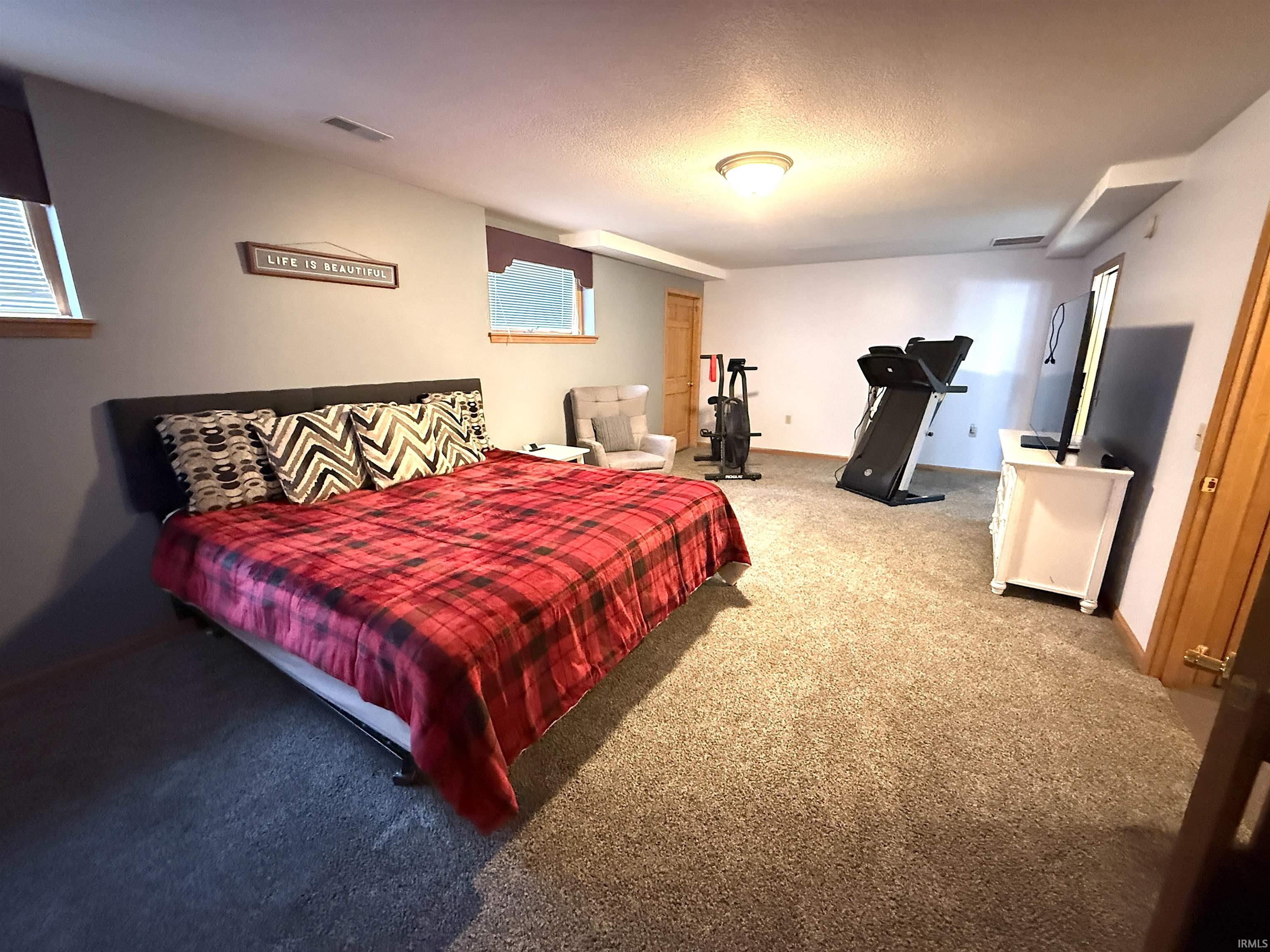 Carpeted bedroom with baseboards and a textured ceiling
