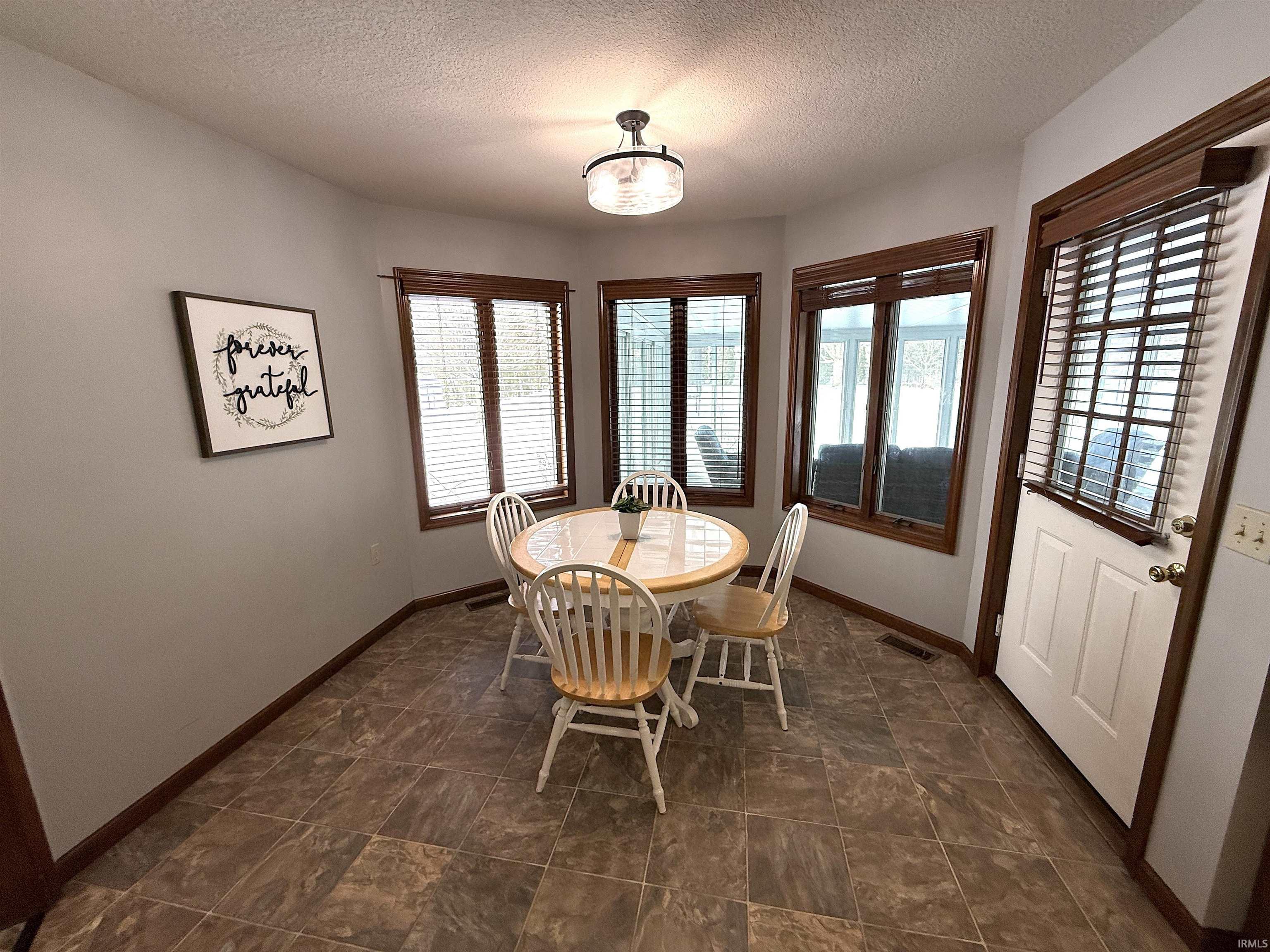 Dining room with baseboards and a textured ceiling