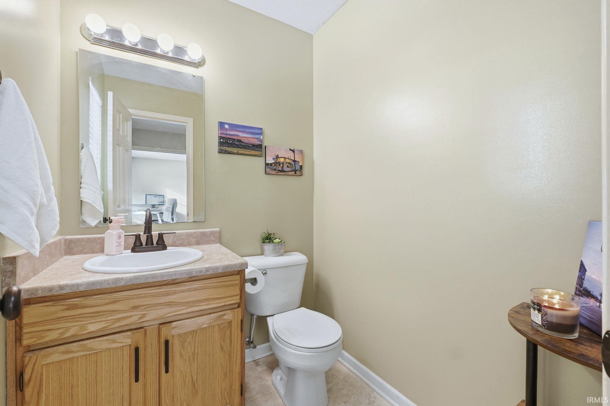 Half bath featuring vanity and light tile patterned floors