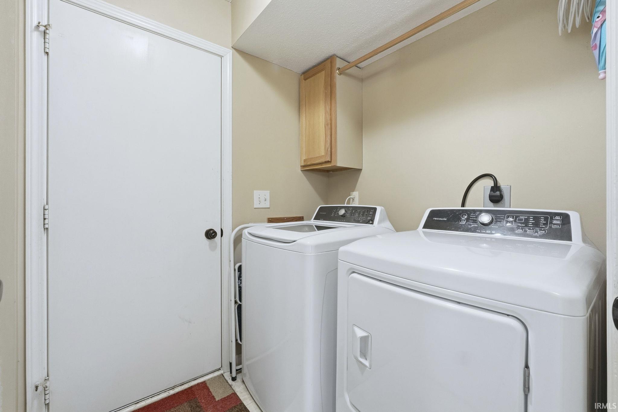 Laundry room featuring independent washer and dryer and cabinet space