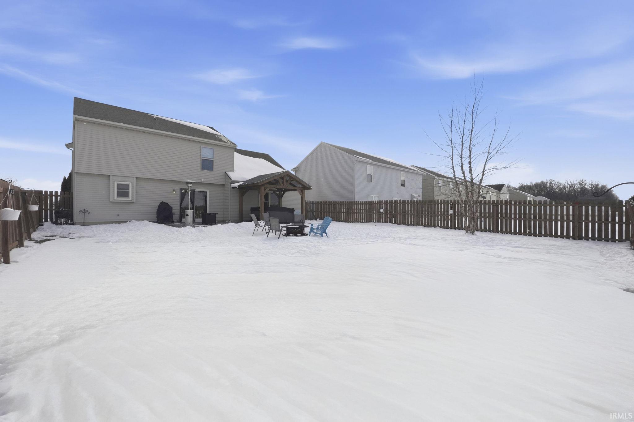 Snow covered house featuring a fenced backyard, a patio, and a gazebo